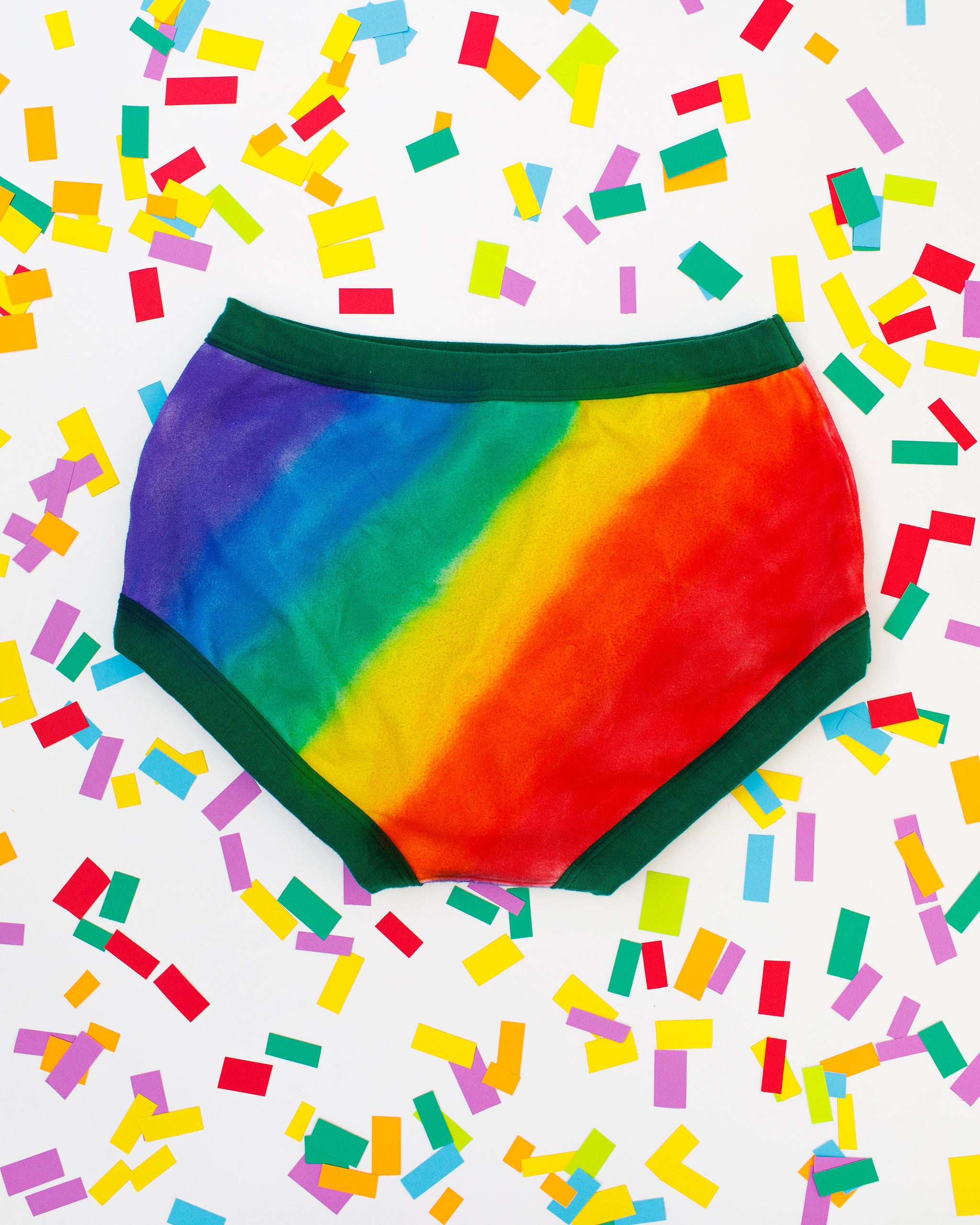 Thunderpants organic cotton Original style underwear in hand painted rainbow stripes for Pride laying on rainbow confetti.