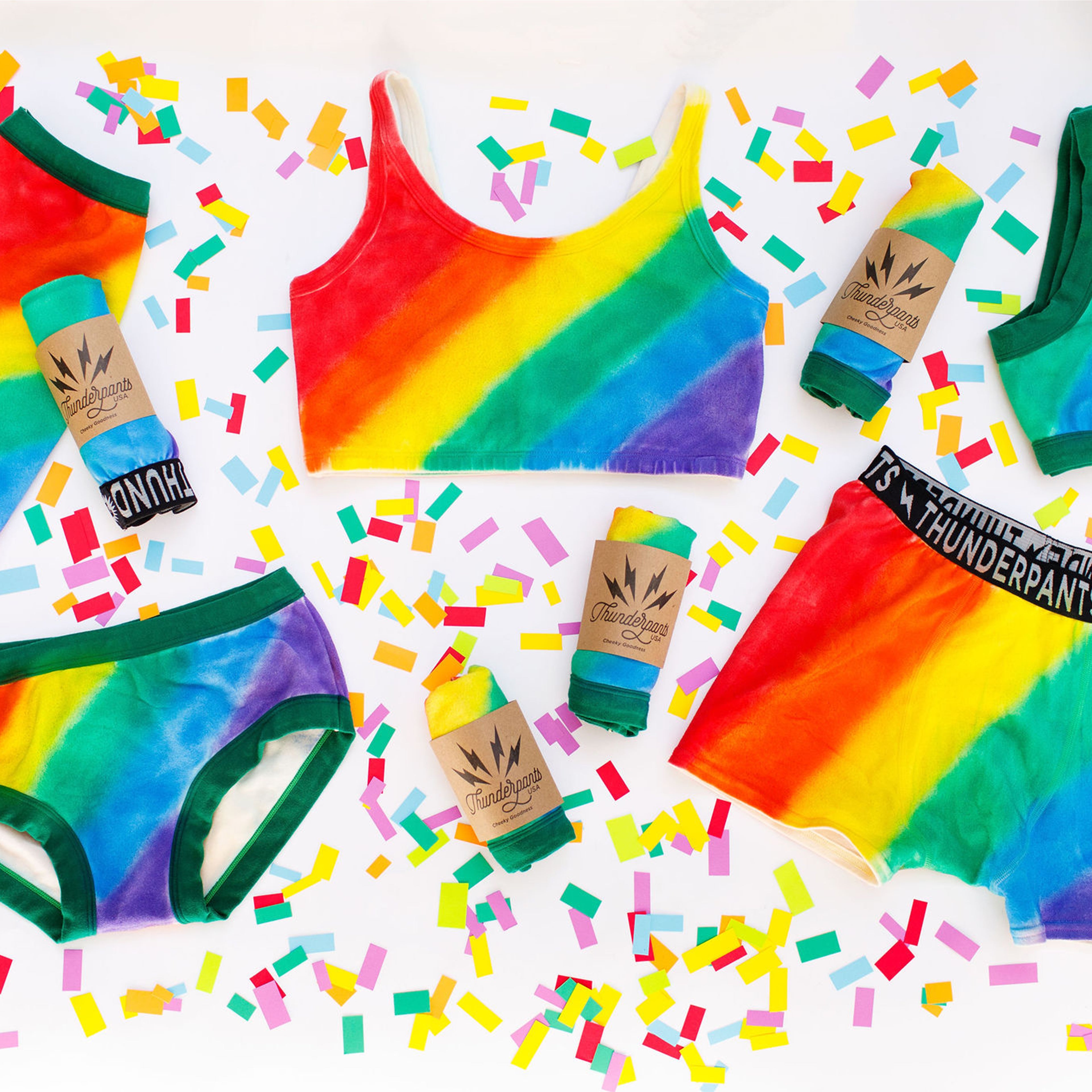 Flat lay of Thunderpants organic cotton products in many styles in the Pride Philanthropants hand painted rainbow print.