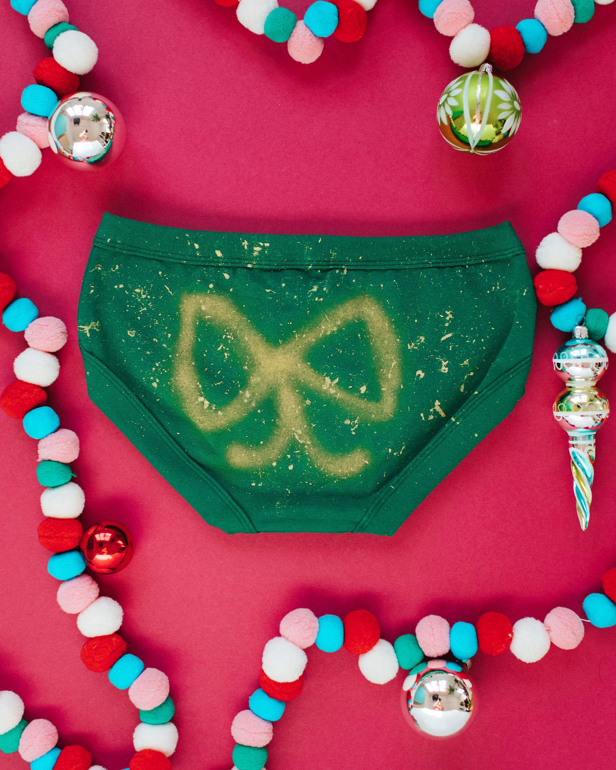 Flat lay of Thunderpants Hipster style underwear in Put a Bow on It: hand painted gold bow.