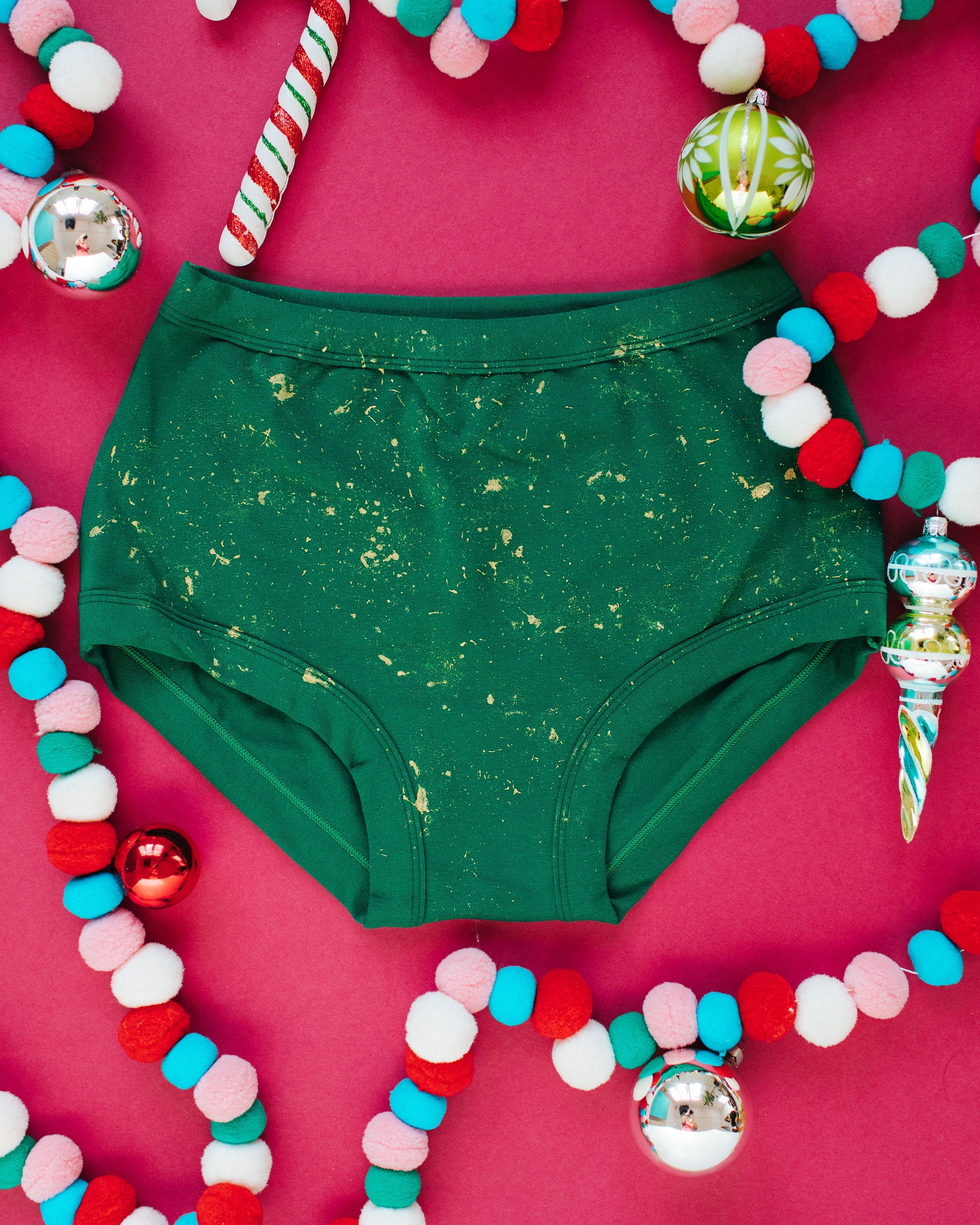 Flat lay of Thunderpants Original style underwear in Put a Bow on It: hand painted gold bow.