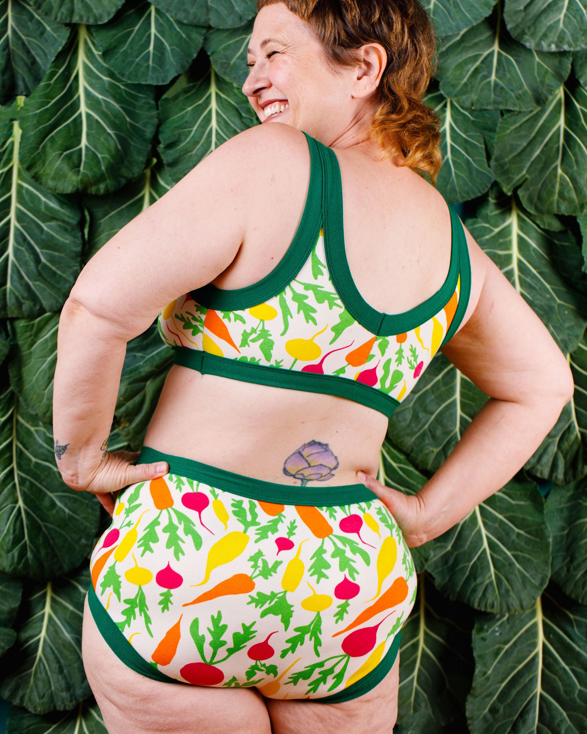 Back of model wearing Thunderants Original style underwear and matching Bralette in Root Veggies print - yellow, orange, pink, and green vegetables.