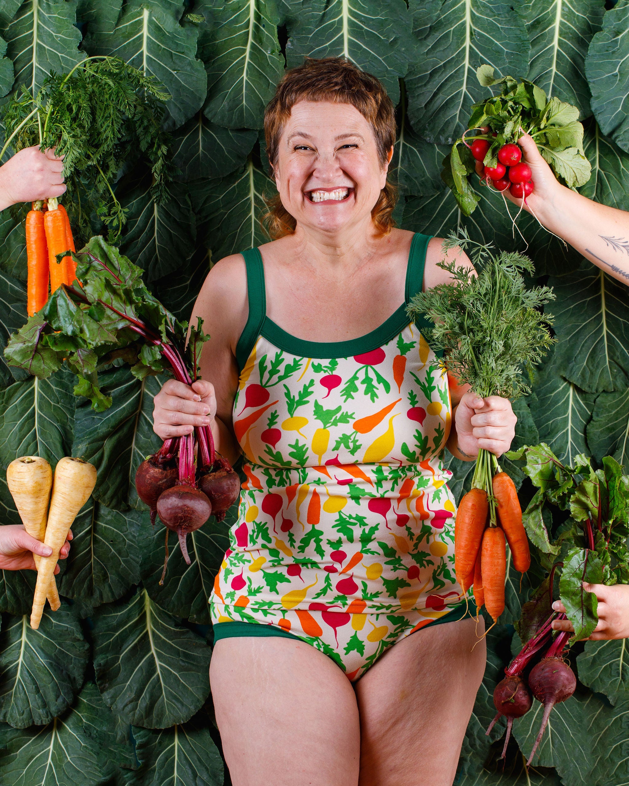 Model smiling wearing Thunderants Camisole and Hipster style underwear  in Root Veggies print - yellow, orange, pink, and green vegetables.