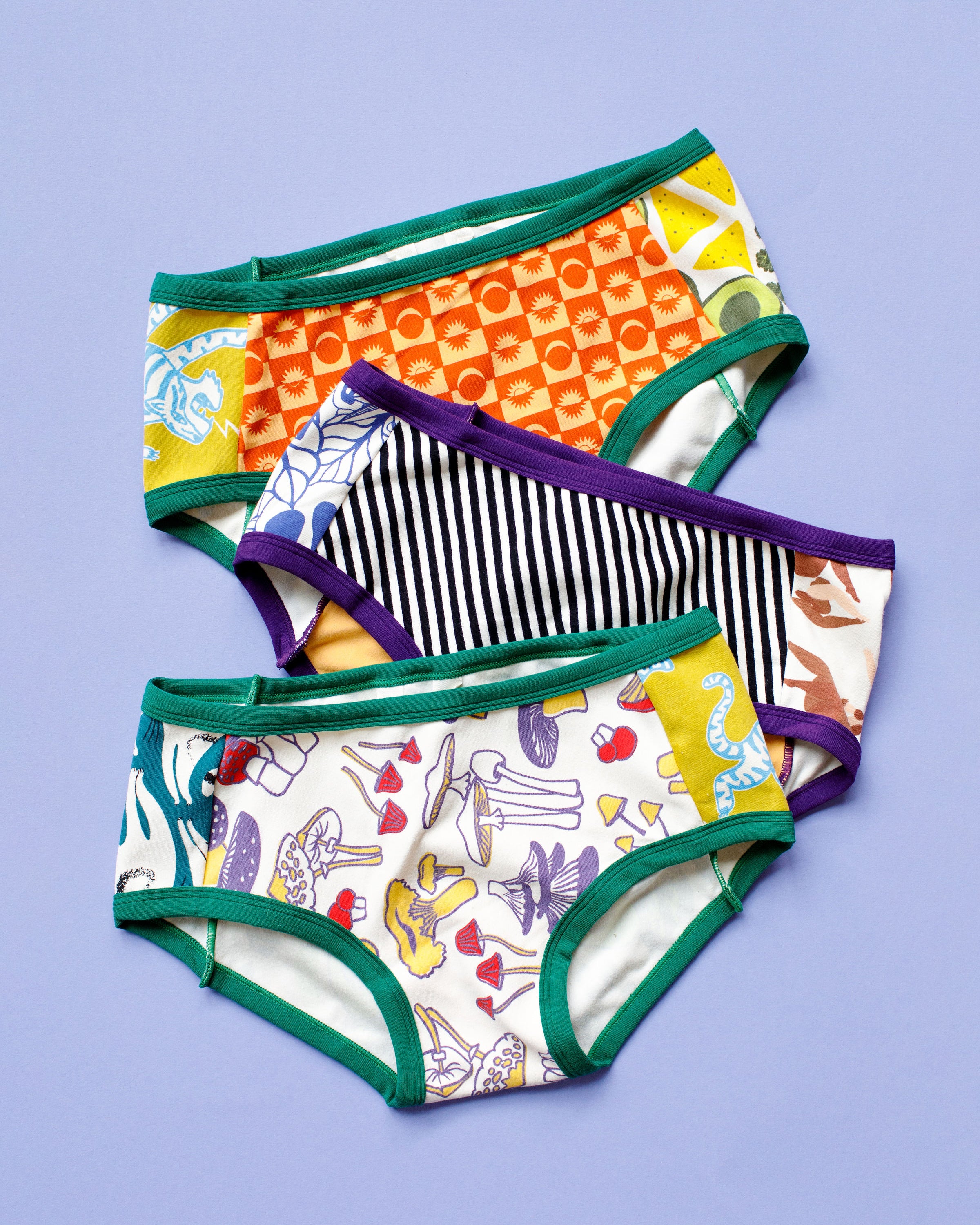 Flat lay of three Thunderpants Hipster style underwear in Scrap Panel Pants on a purple background - various current and past prints in one pair of underwear.