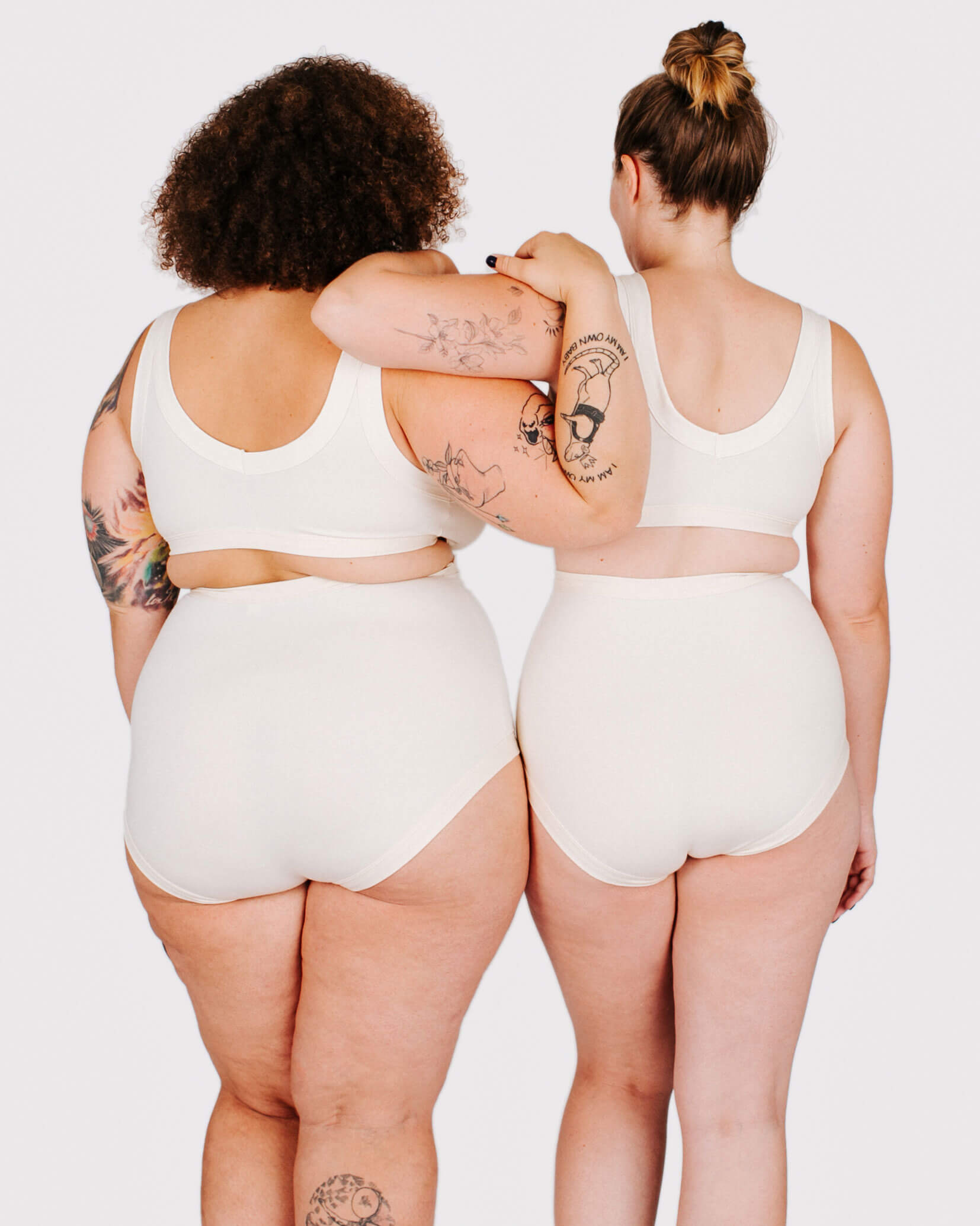 Fit photo from the back of Thunderpants organic cotton Sky Rise style underwear and Bralette in off-white on two models standing together.