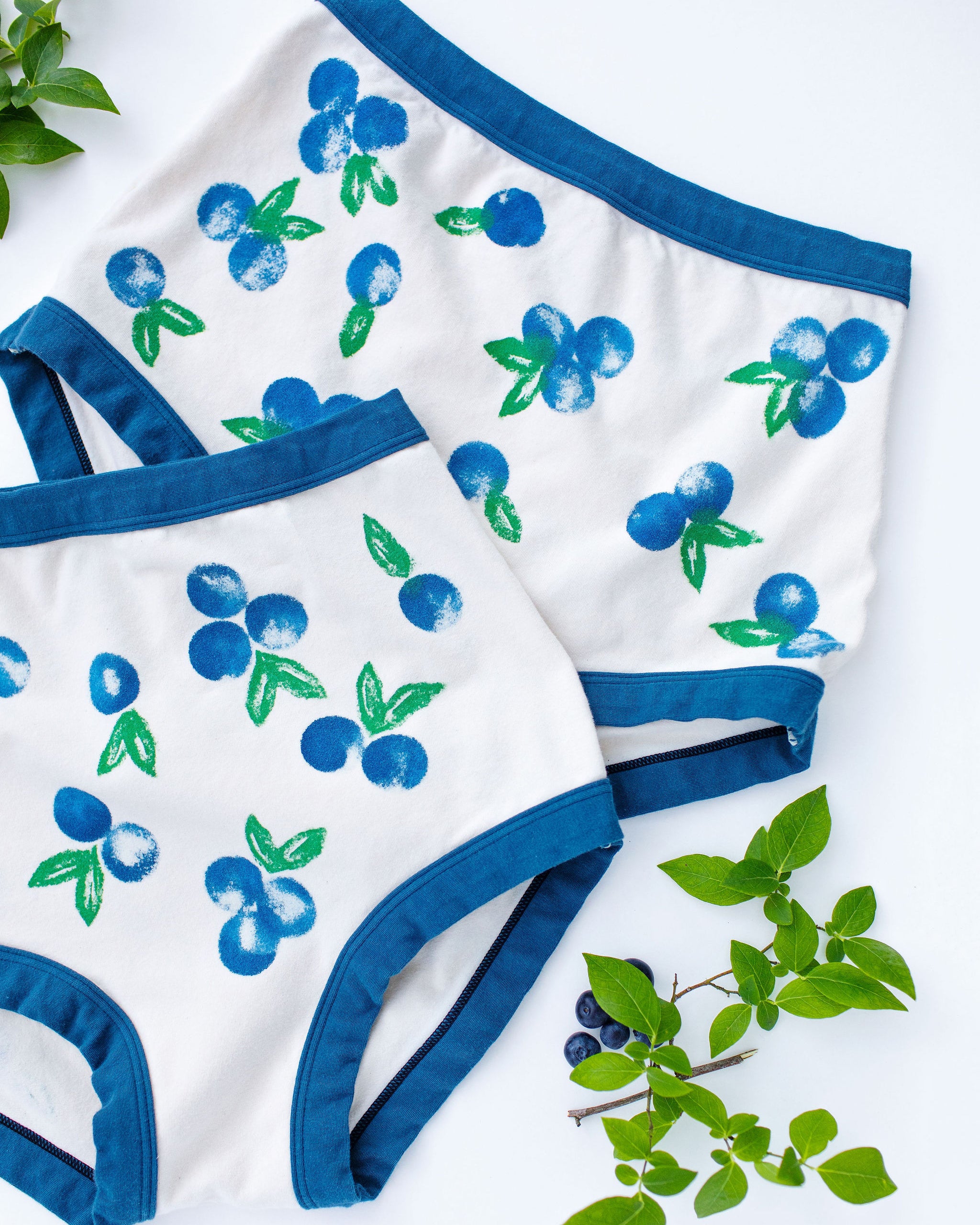 Flat lay of Thunderpants Sky Rise style underwear with a blue and green Blueberry print and blue binding. 