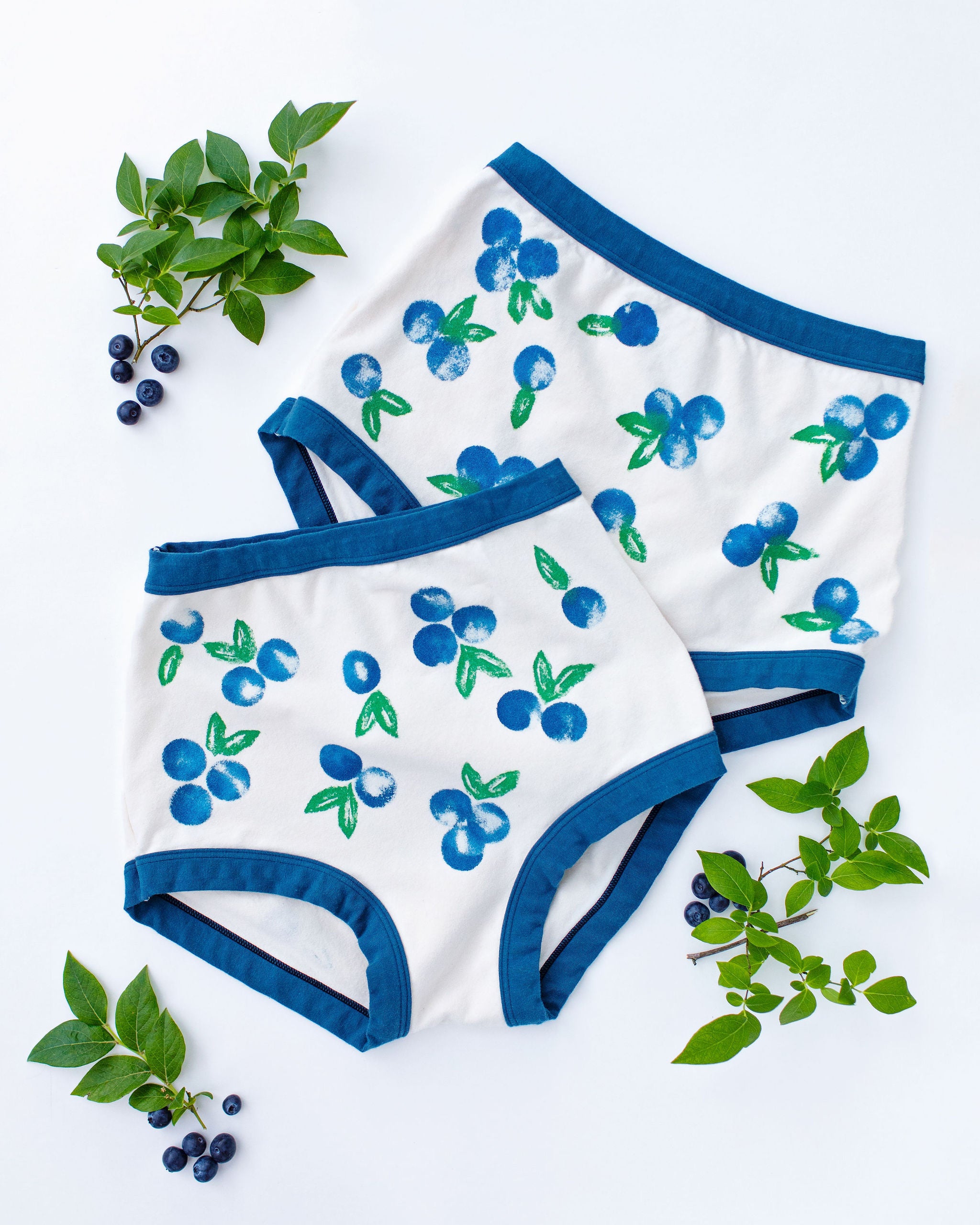Flat lay of Thunderpants Sky Rise style underwear with a blue and green Blueberry print and blue binding. 