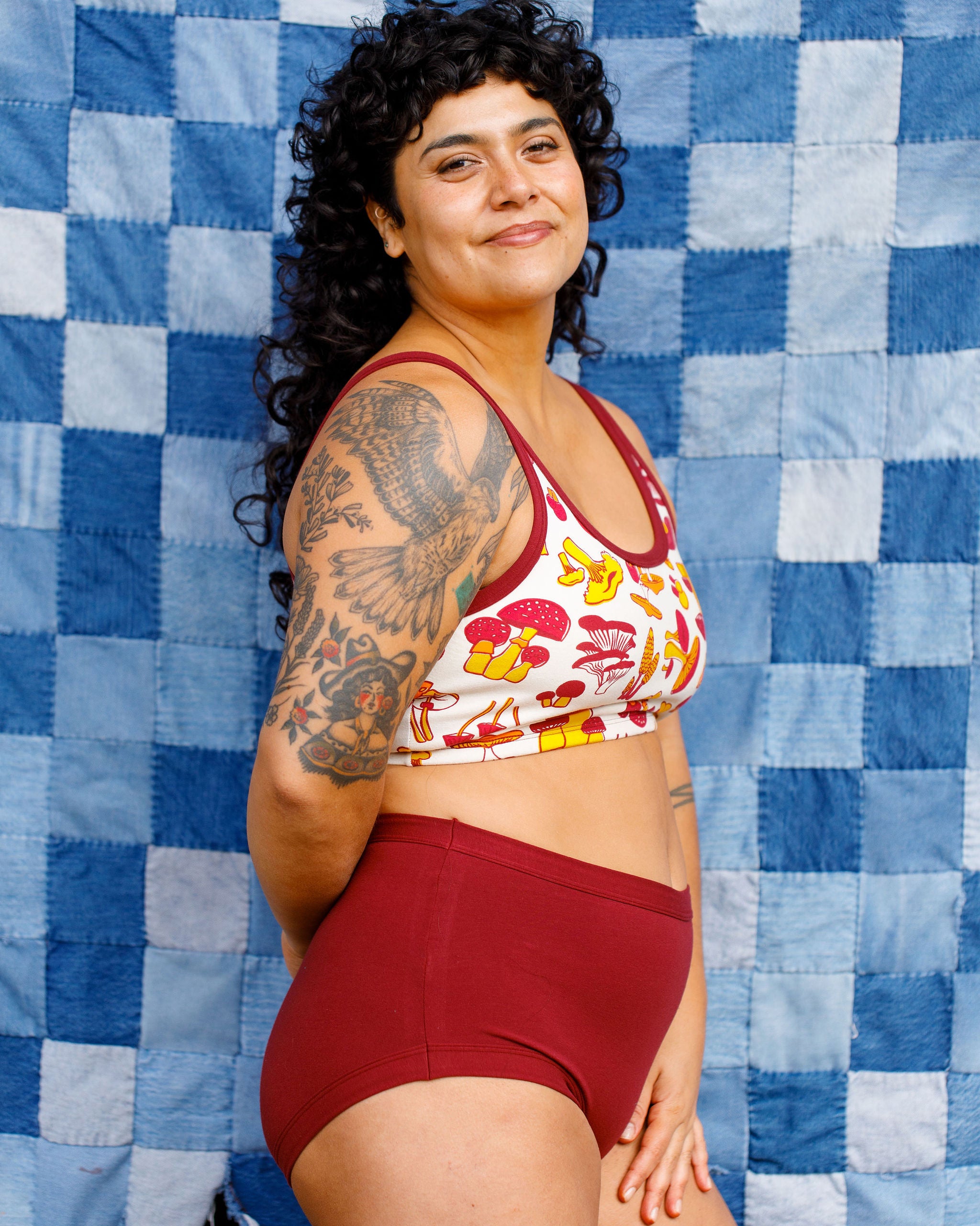 Model wearing Thunderpants Sky Rise style underwear in Cabern-YAY (a deep wine red color) and a Longline Bra in a mushroom print.