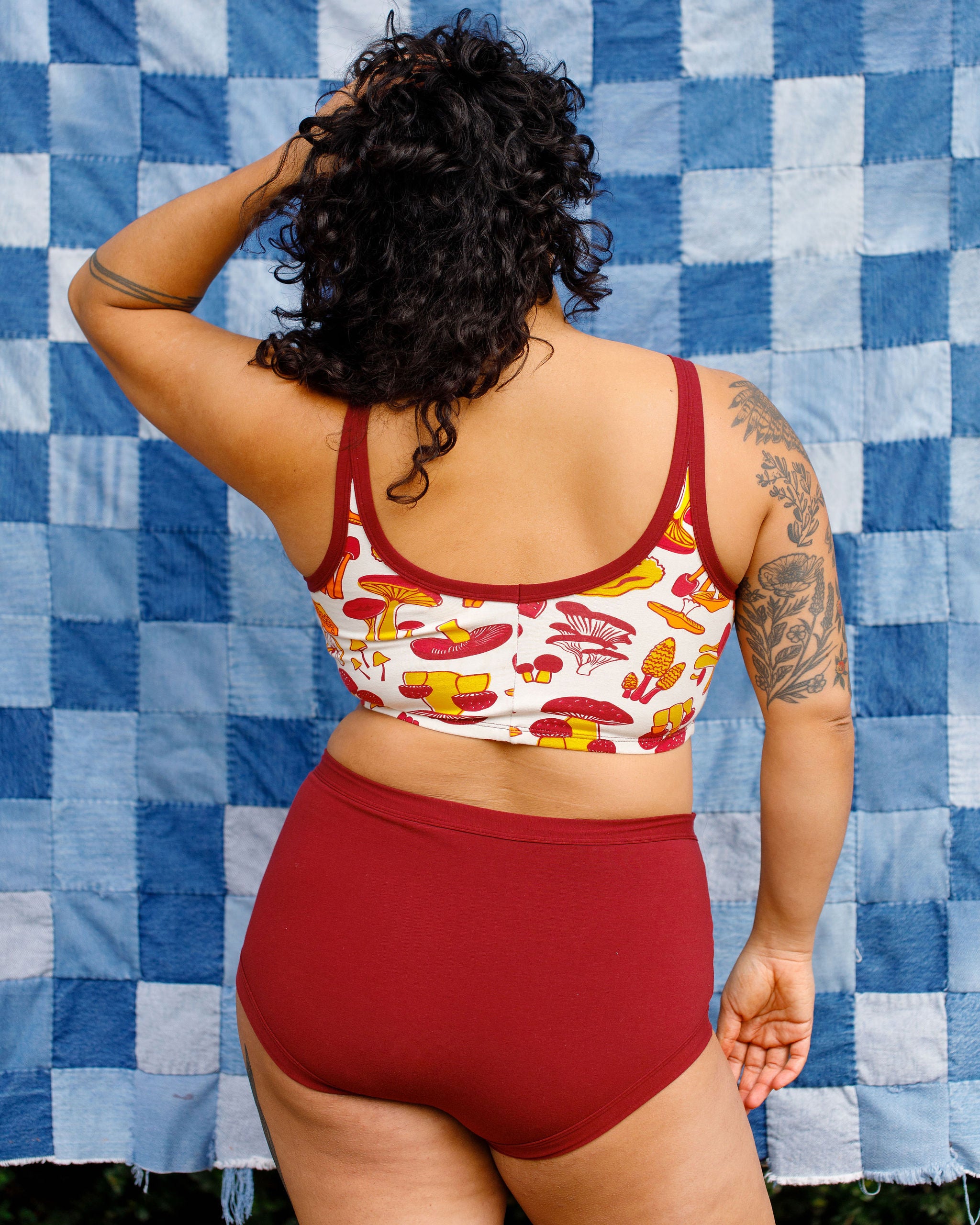 Model wearing Thunderpants Sky Rise style underwear in Cabern-YAY (a deep wine red color) and a Longline Bra in a mushroom print.