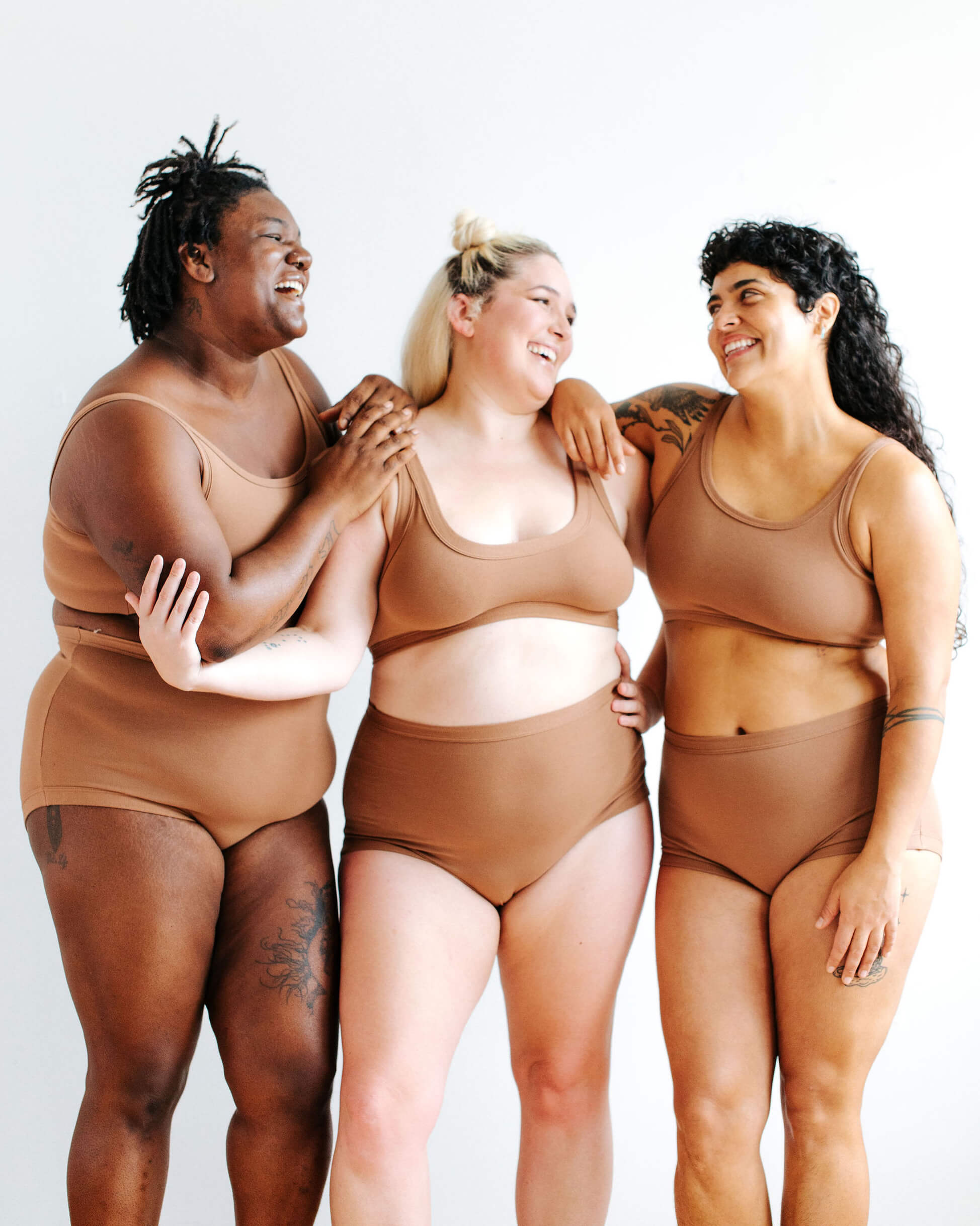 Three models wearing Thunderpants Sky Rise style underwear and longline bra in Hazelnut color.