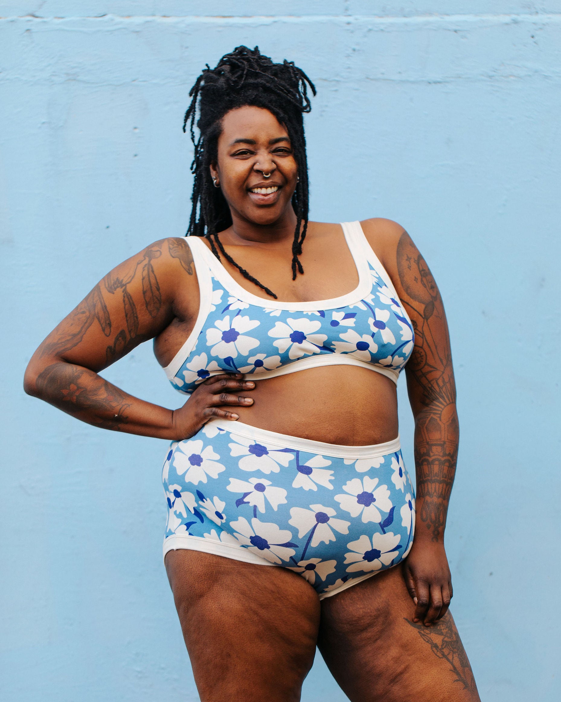 Model wearing Thunderpants Sky Rise style underwear and Bralette in Moody Blooms - white and blue flowers with blue background.