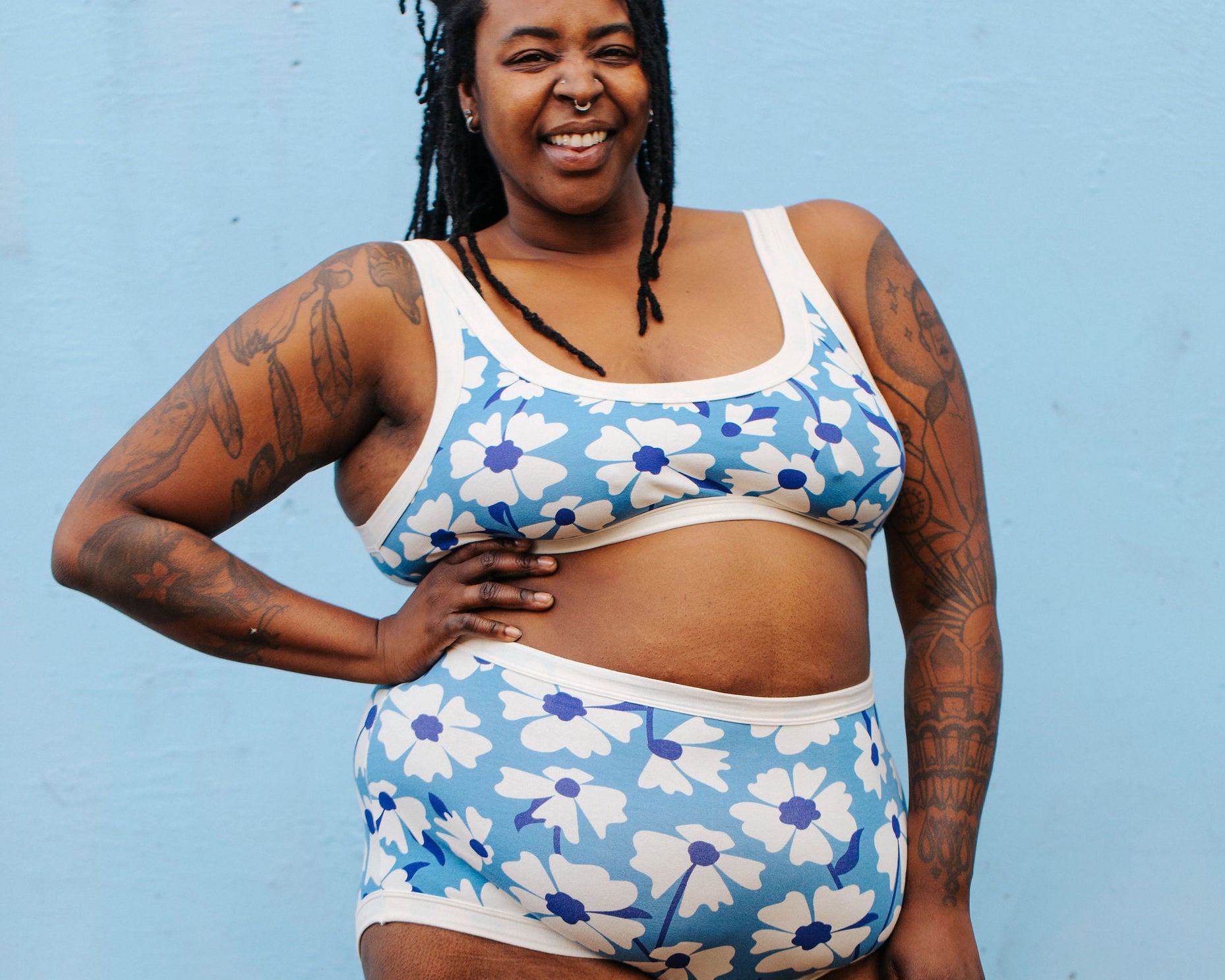 Model wearing Thunderpants Sky Rise style underwear and Bralette in Moody Blooms - white and blue flowers with blue background.