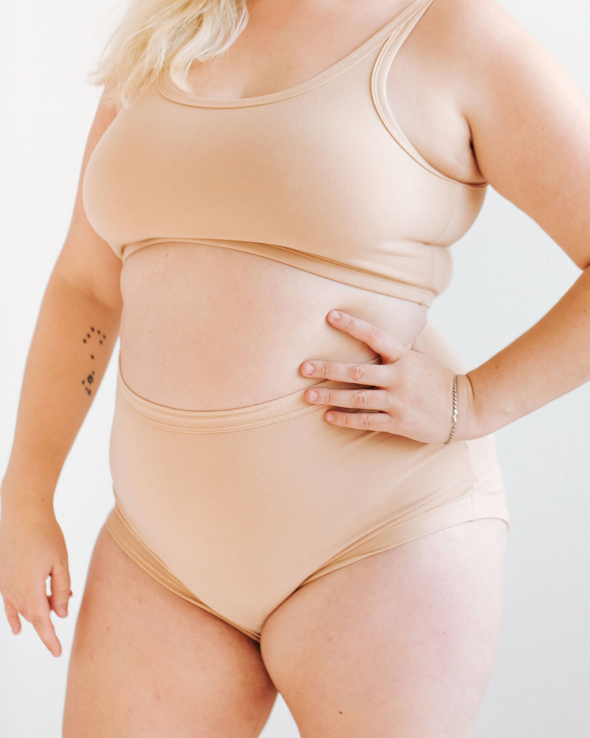 Close up of model wearing Thunderpants Sky Rise style underwear and Longline Bra in Pine Nut - lighter tan color.