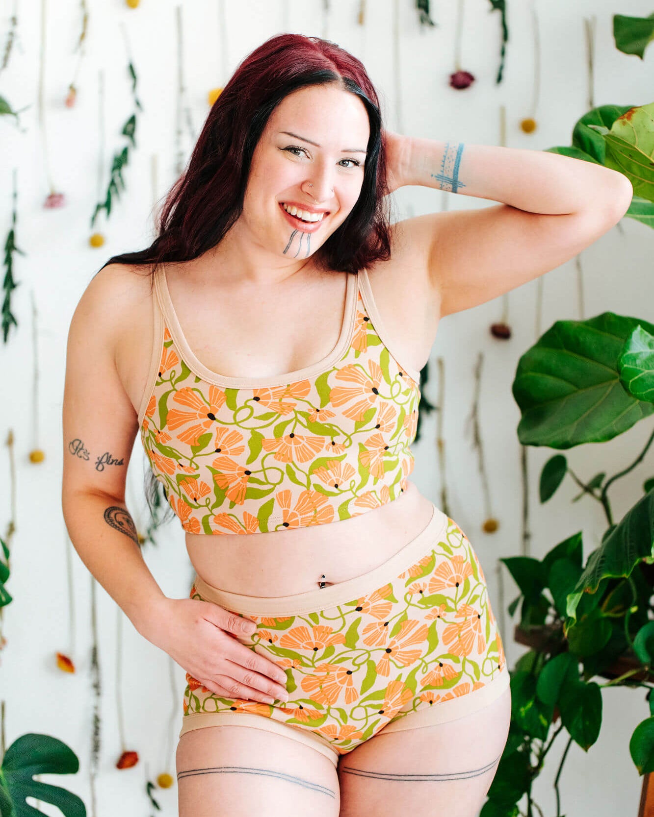 Model wearing a set of Thunderpants Sky Rise style underwear and Longline Bra in Secret Garden print - orange flowers and green leaves.