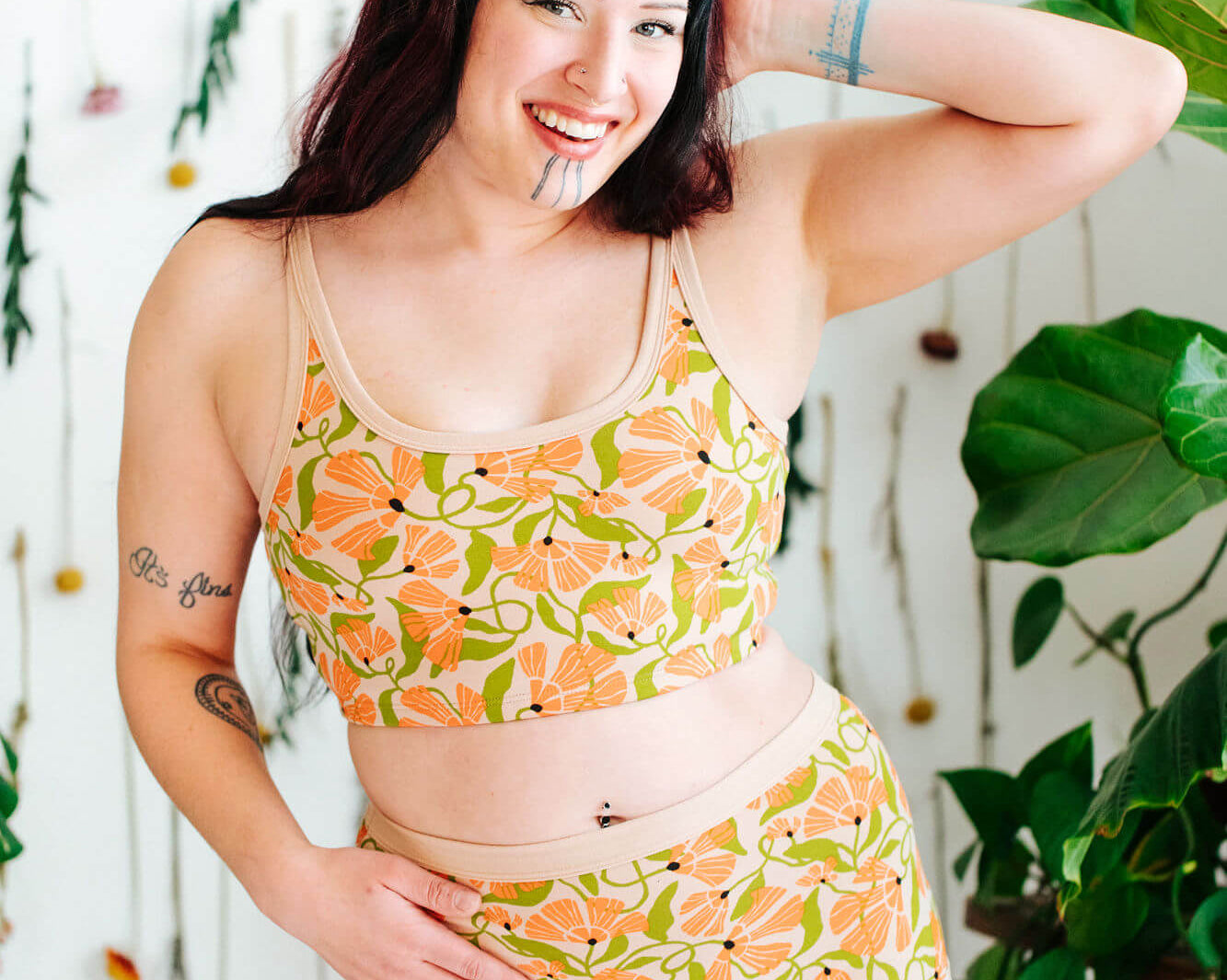 Model wearing a set of Thunderpants Sky Rise style underwear and Longline Bra in Secret Garden print - orange flowers and green leaves.