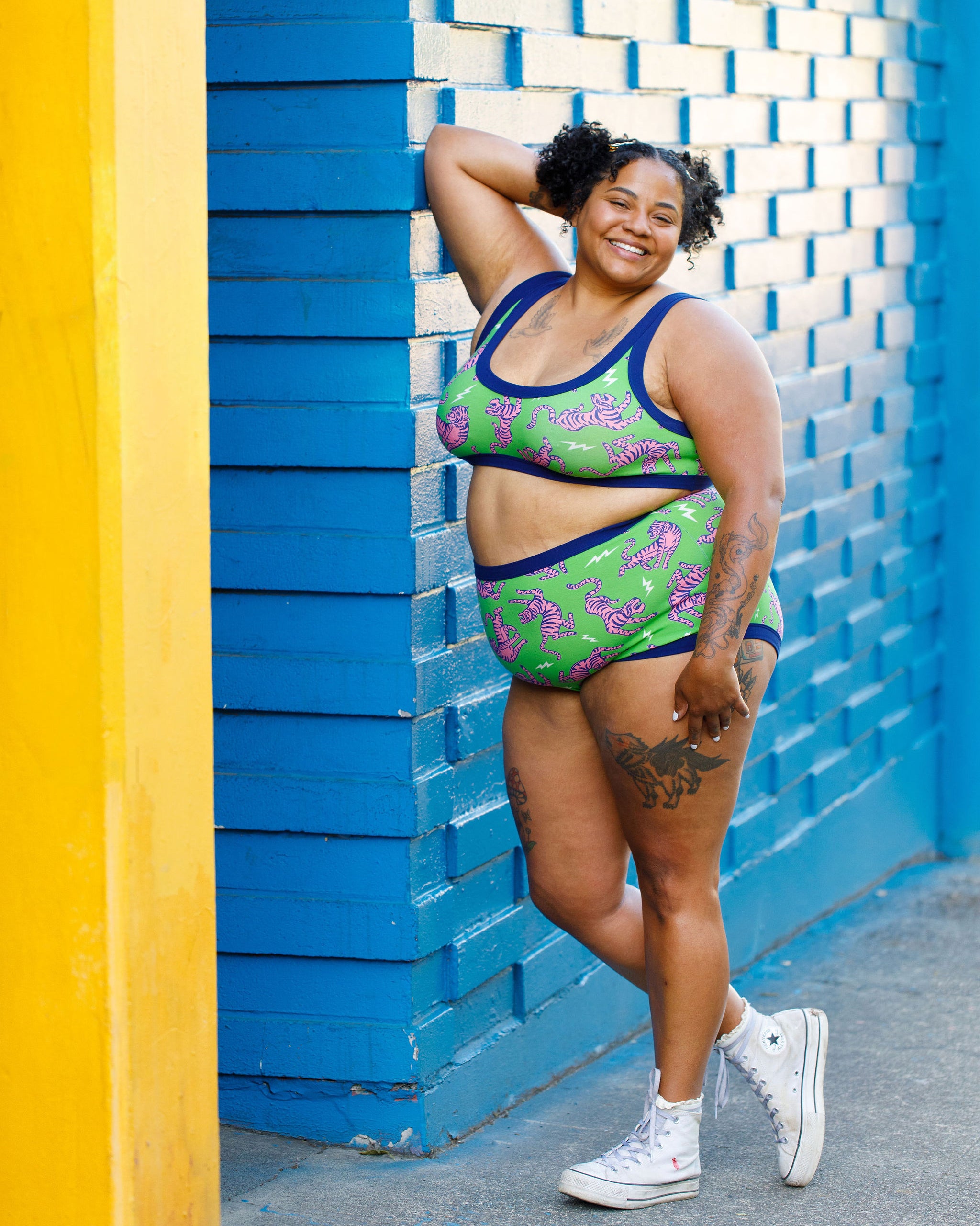Model wearing Thunderpants organic cotton Sky Rise style underwear and Bralette in Electric Tiger - green with pink and blue tigers and white lightning bolts.