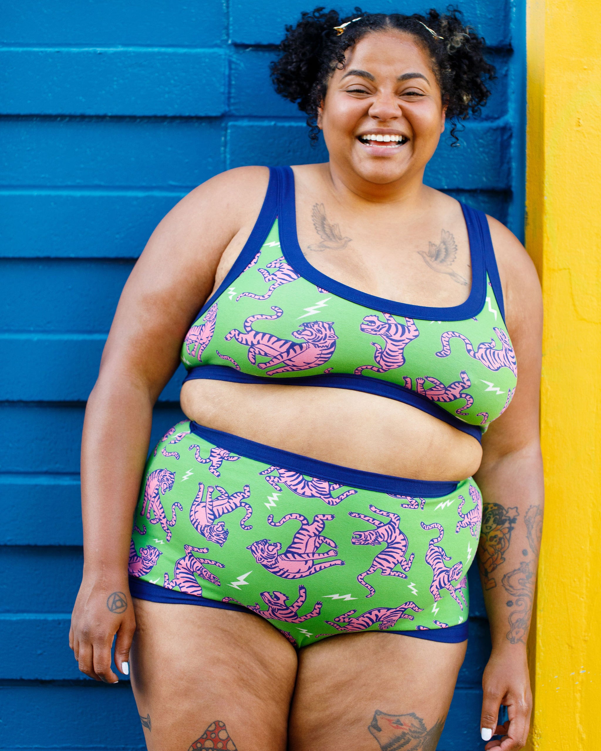 Model wearing Thunderpants organic cotton Sky Rise style underwear and Bralette in Electric Tiger - green with pink and blue tigers and white lightning bolts.