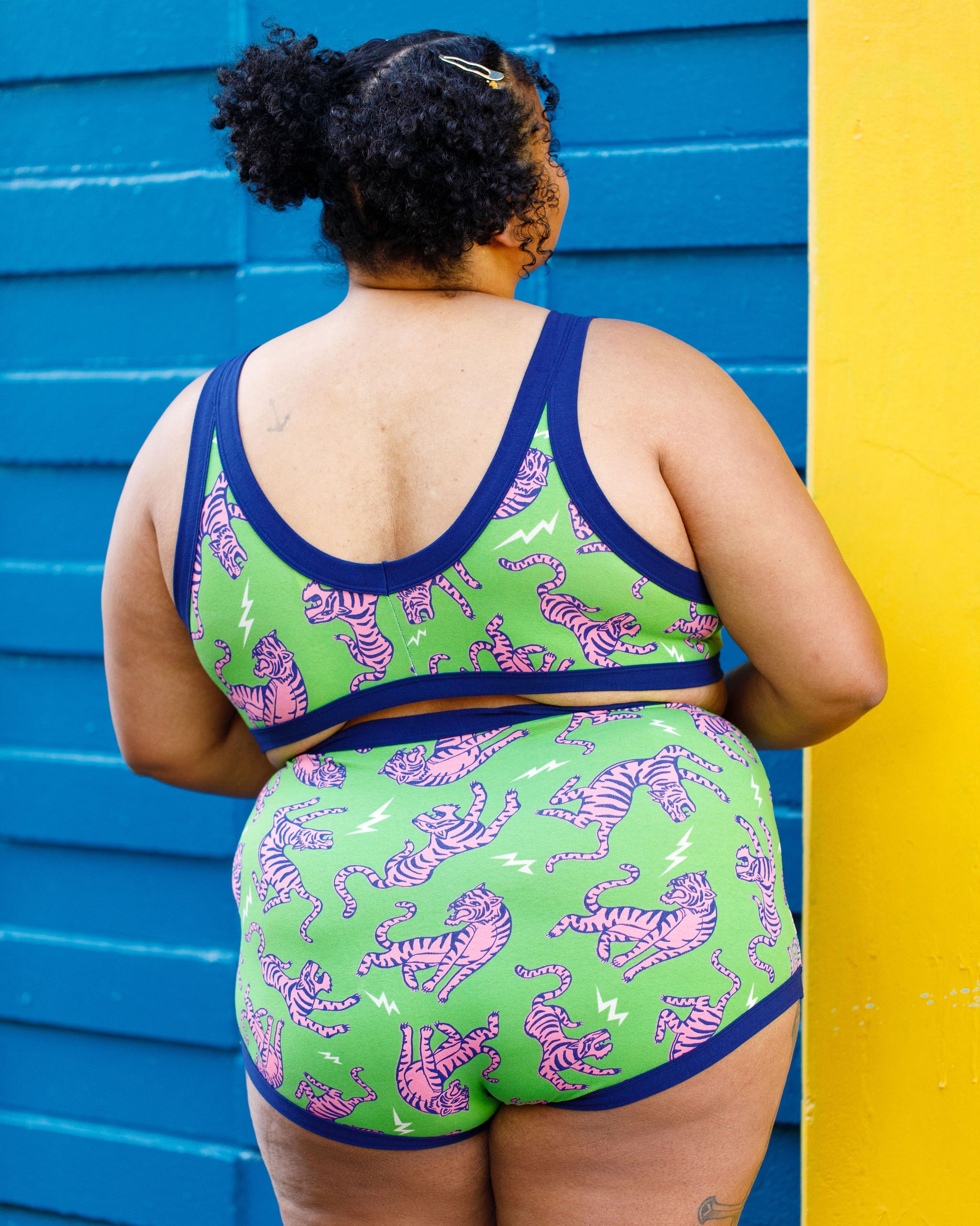 Model wearing Thunderpants organic cotton Sky Rise style underwear and Bralette in Electric Tiger - green with pink and blue tigers and white lightning bolts.