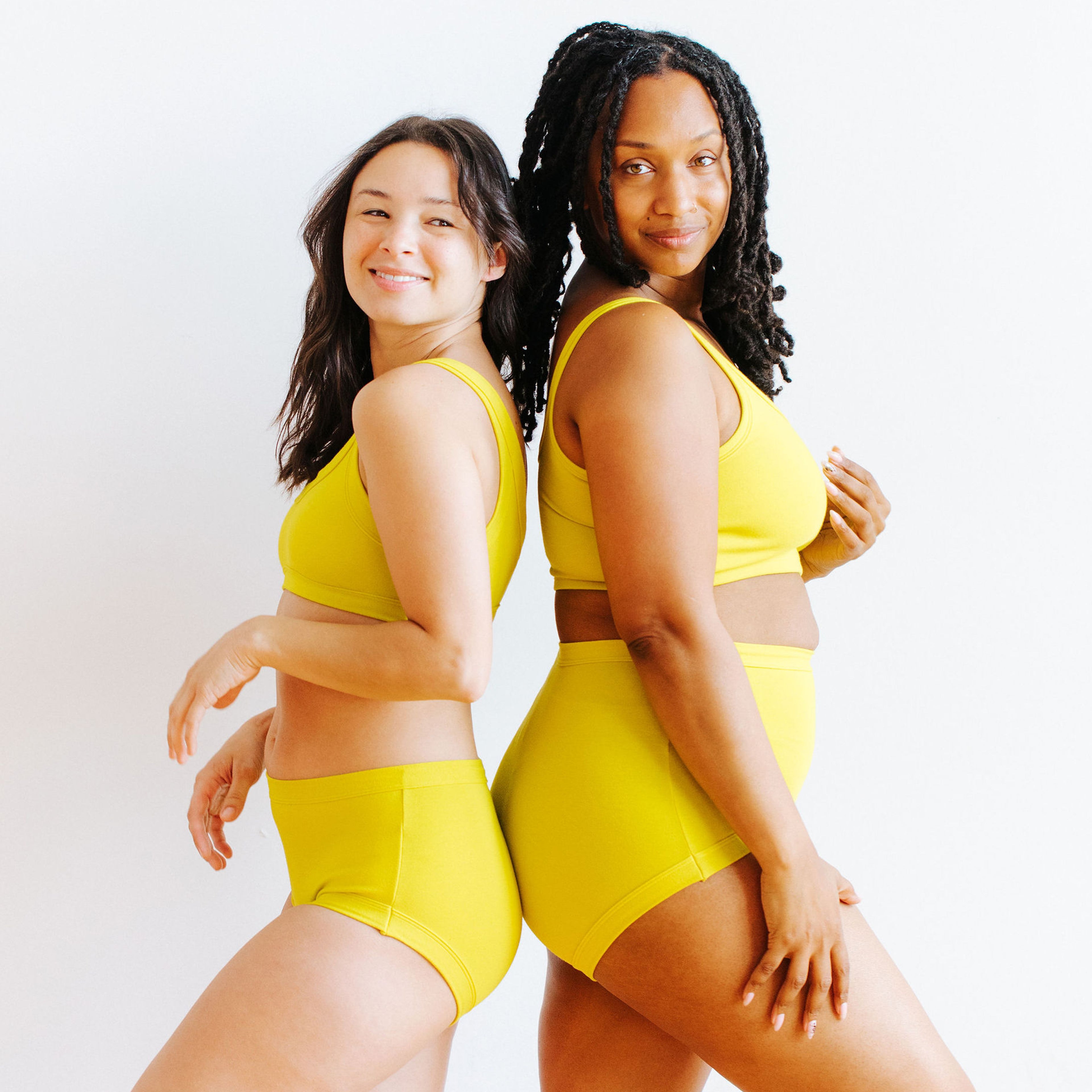 Two models wearing Thunderpants underwear and bra sets in Star Fruit - a chartreuse yellow color.