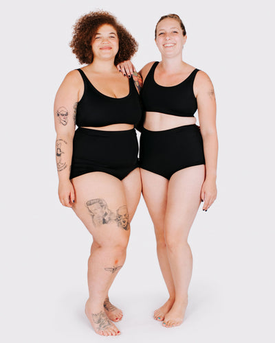 Fit photo from the front of Thunderpants recycled nylon Swimwear Sky Rise style bottoms and Swimwear Top in Plain Black on two models standing together.