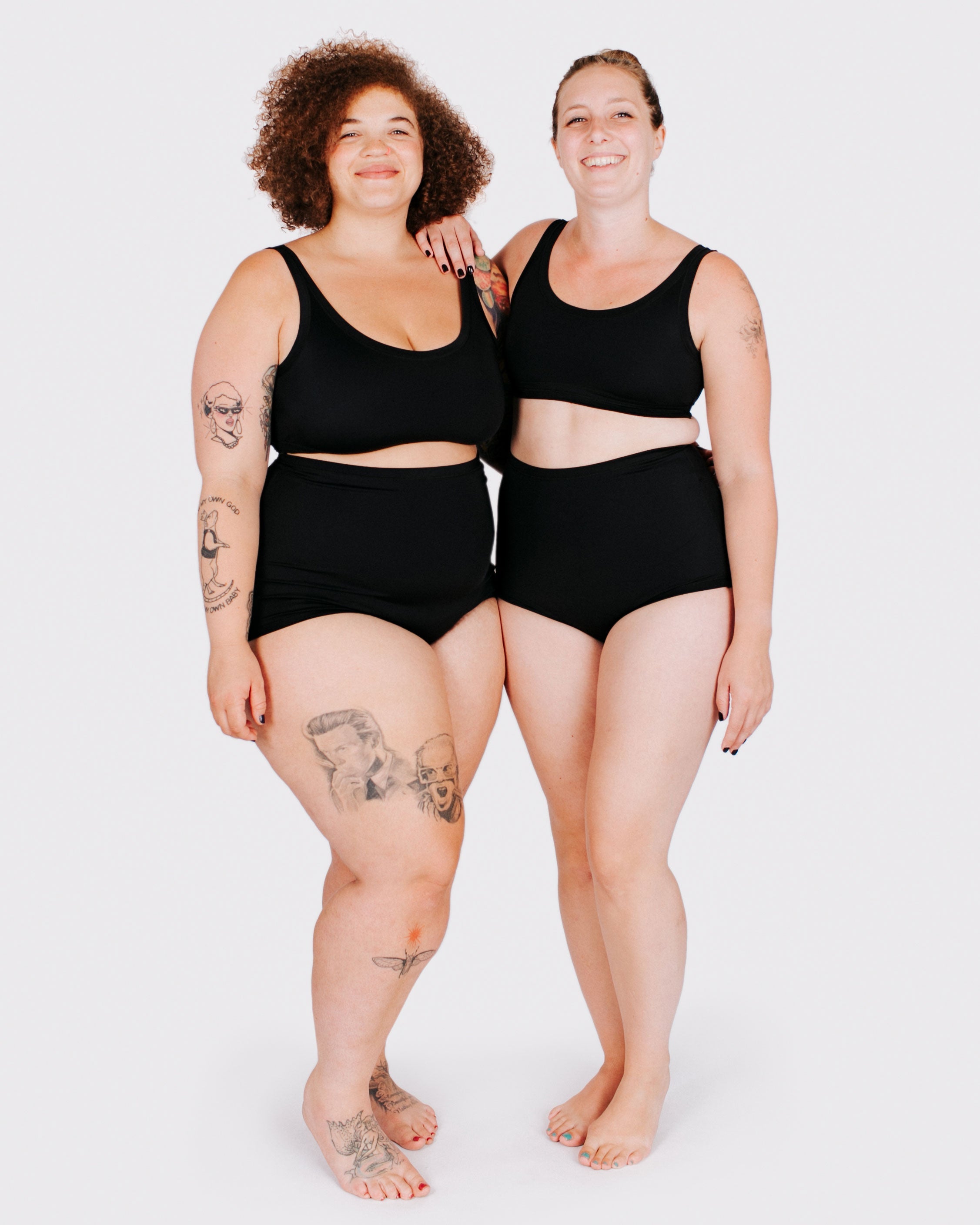 Fit photo from the front of Thunderpants recycled nylon Swimwear Sky Rise style bottoms and Swimwear Top in Plain Black on two models standing together.