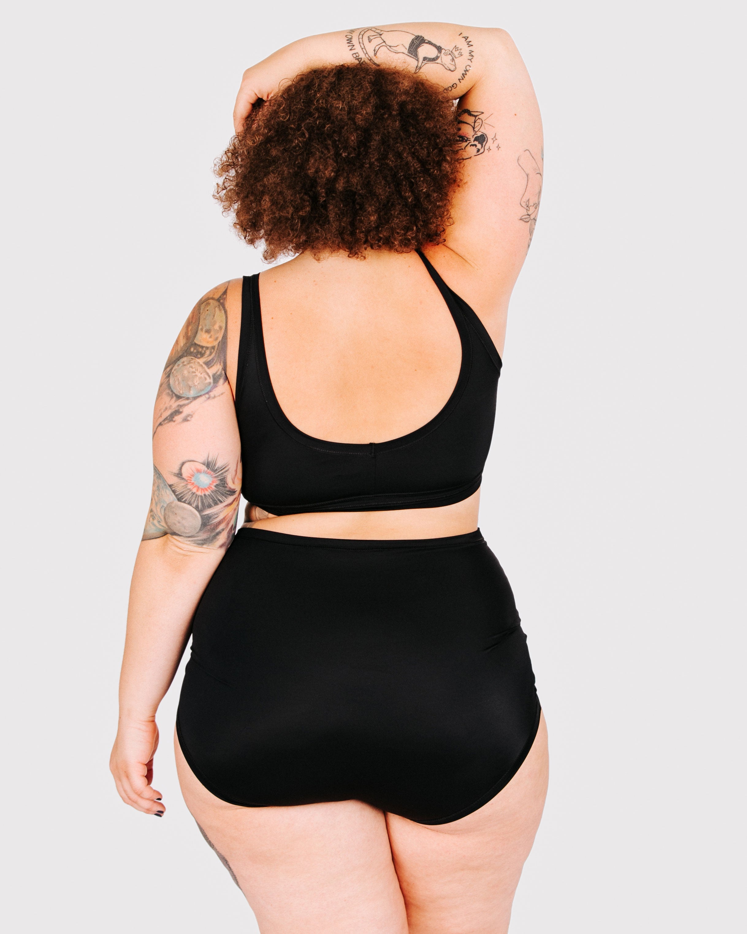 Fit photo from the back of Thunderpants recycled nylon Swimwear Sky Rise style bottoms in Plain Black, showing a wedgie-free bum, on a model.