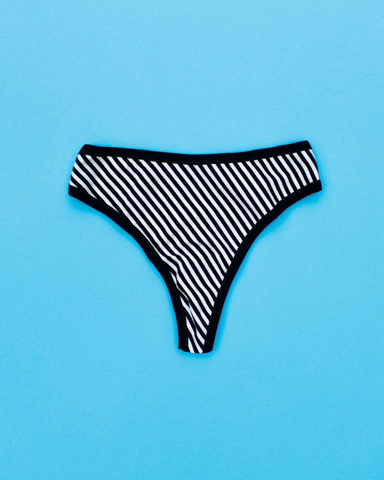 Flat lay of Thunderpants Organic Cotton Thong style underwear in Black and White Stripe.