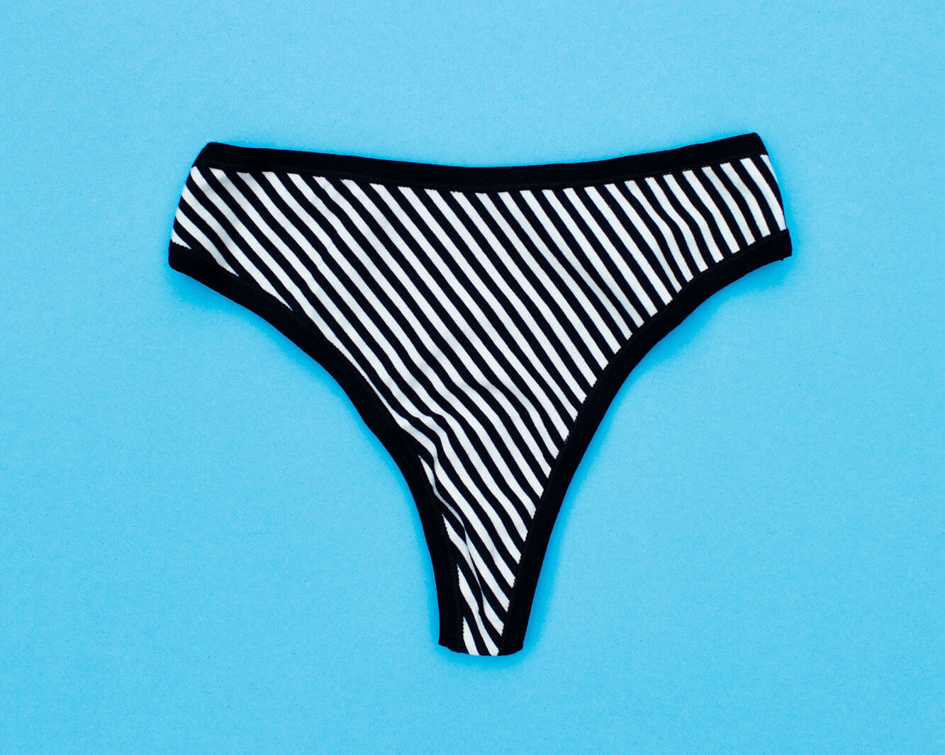 Flat lay of Thunderpants Organic Cotton Thong style underwear in Black and White Stripe.