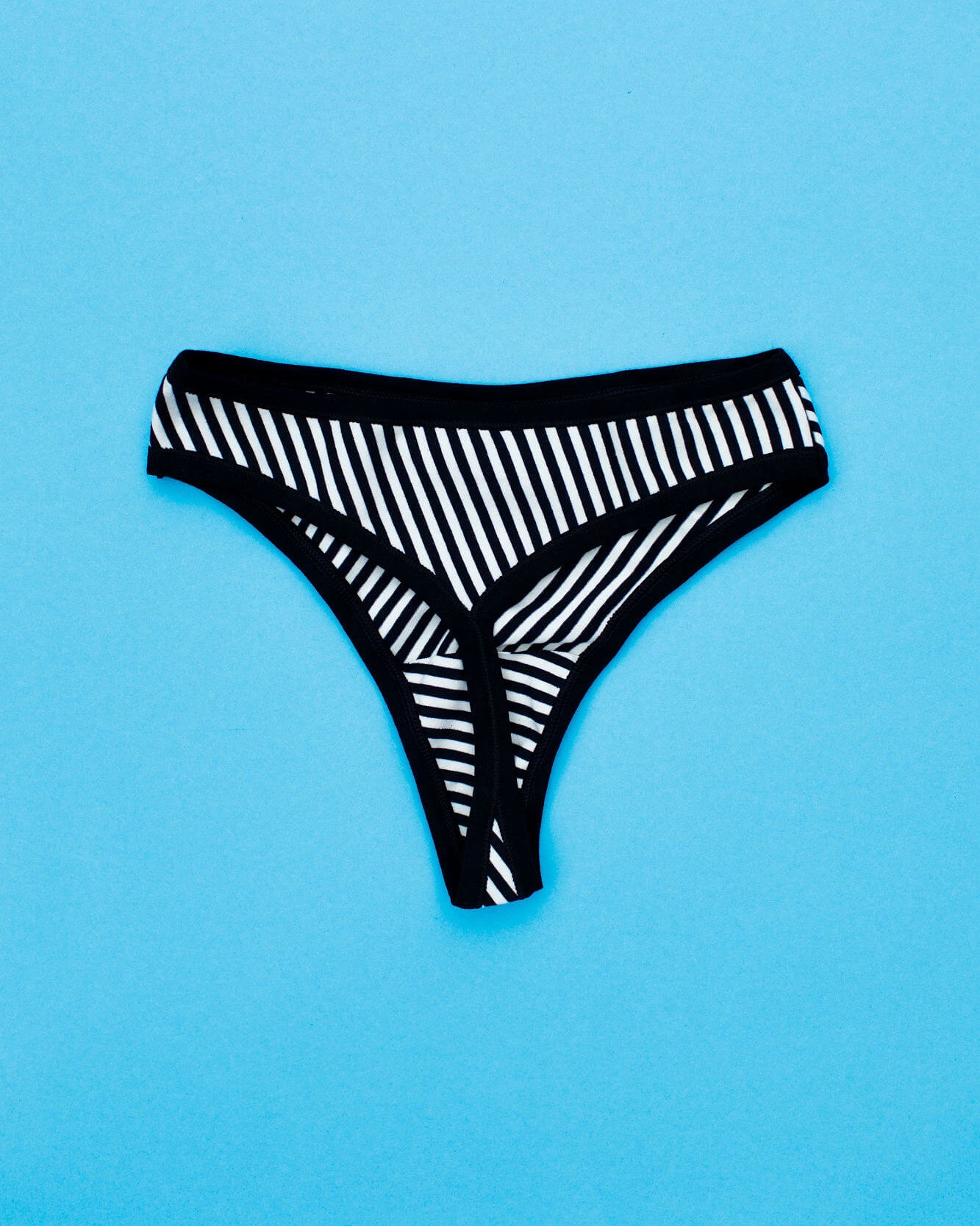 Flat lay of Thunderpants Organic Cotton Thong style underwear in Black and White Stripe.