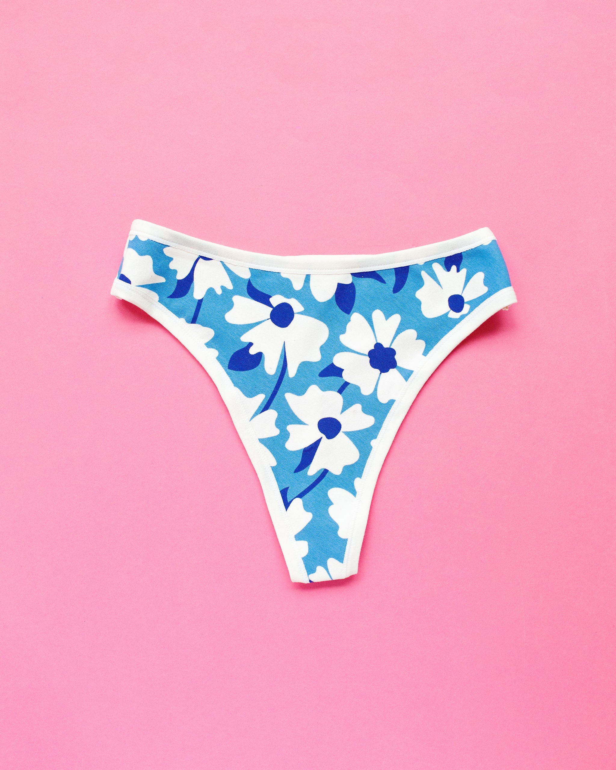 Flat lay of Thunderpants Thong style underwear in Moody Blooms - blue and white flowers.