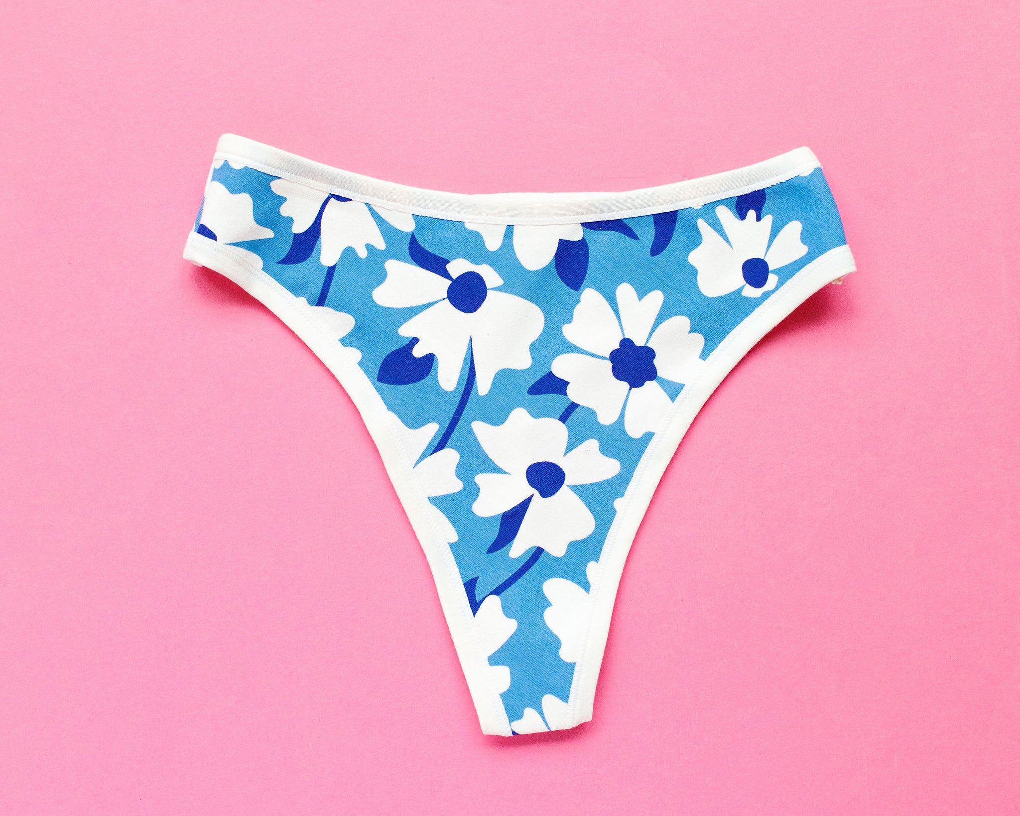 Flat lay of Thunderpants Thong style underwear in Moody Blooms - blue and white flowers.