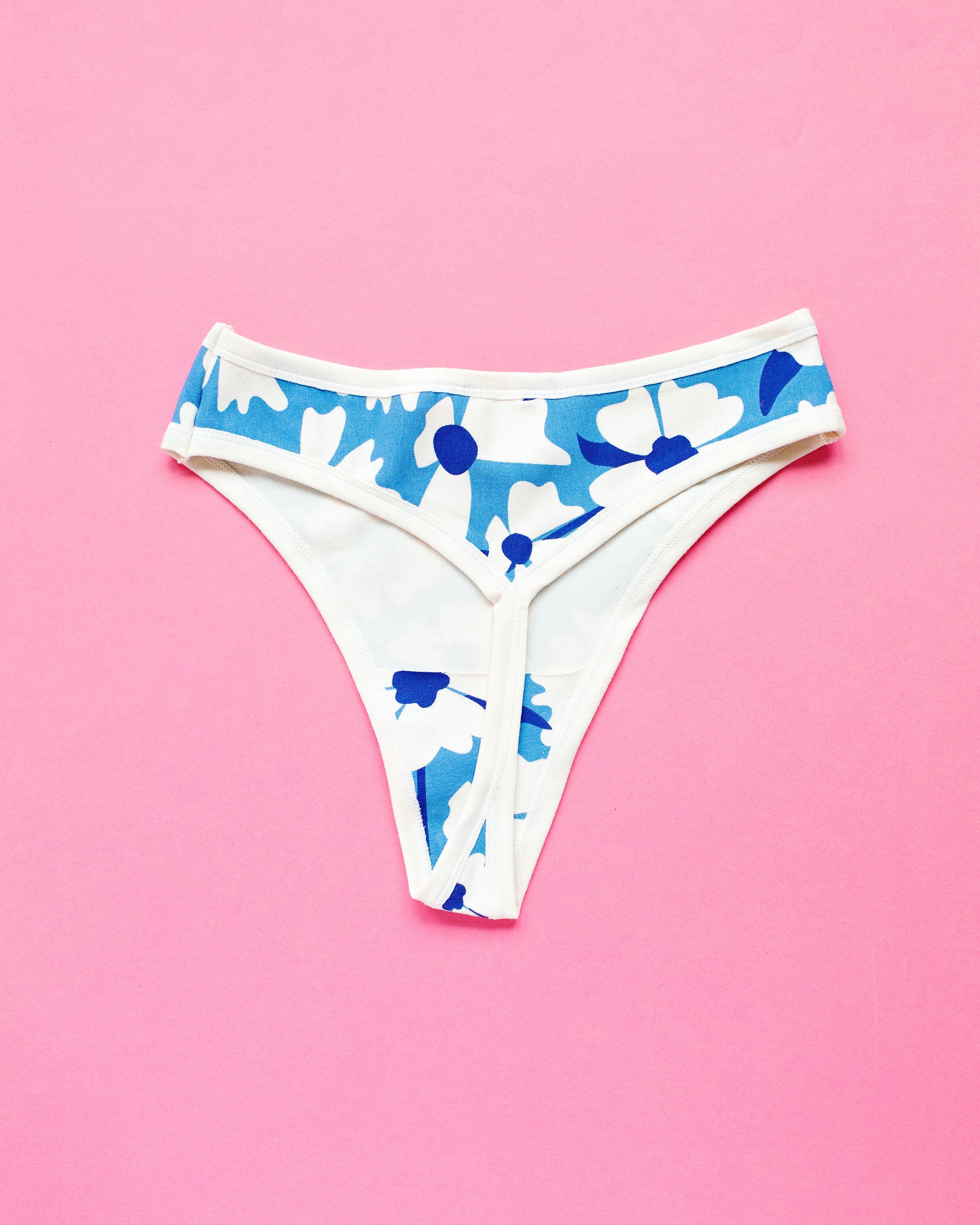 Flat lay of Thunderpants Thong style underwear in Moody Blooms - blue and white flowers.