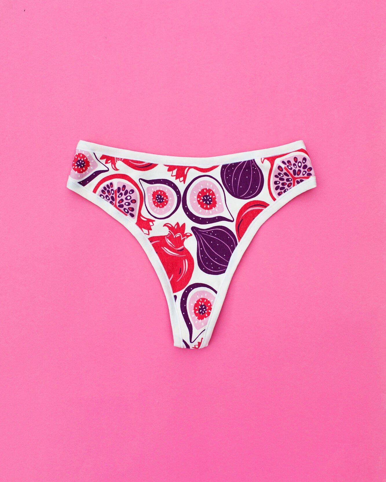 Flat lay of Thunderpants Thunder Thong in Two Fruits print - Pomegranates and Figs.