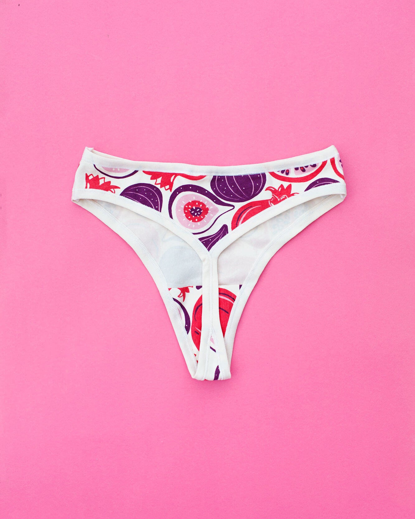 Flat lay of Thunderpants Thunder Thong in Two Fruits print - Pomegranates and Figs.