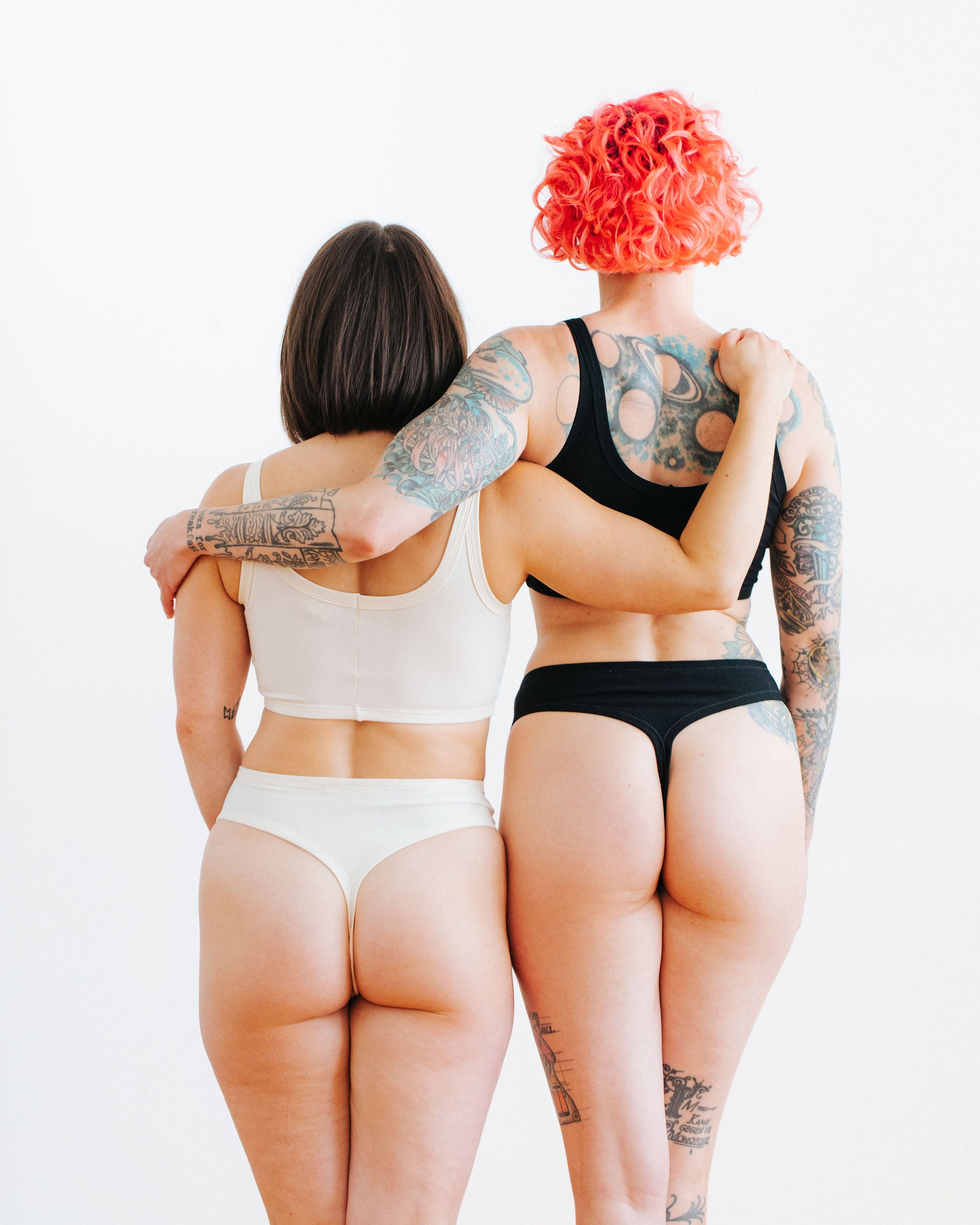 Two models wearing sets in Thunderpants Thong style underwear and Long Line Bra in Plain Vanilla and Plain Black.