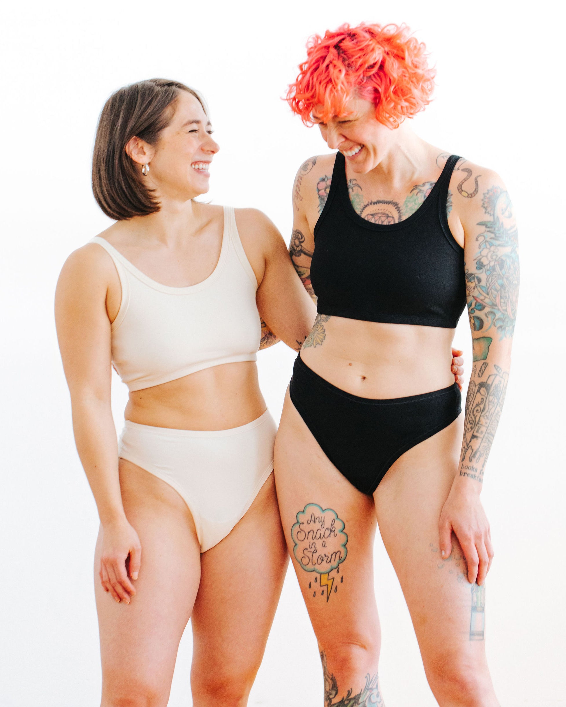 Two models wearing sets in Thunderpants Thong style underwear and Long Line Bra in Plain Vanilla and Plain Black.