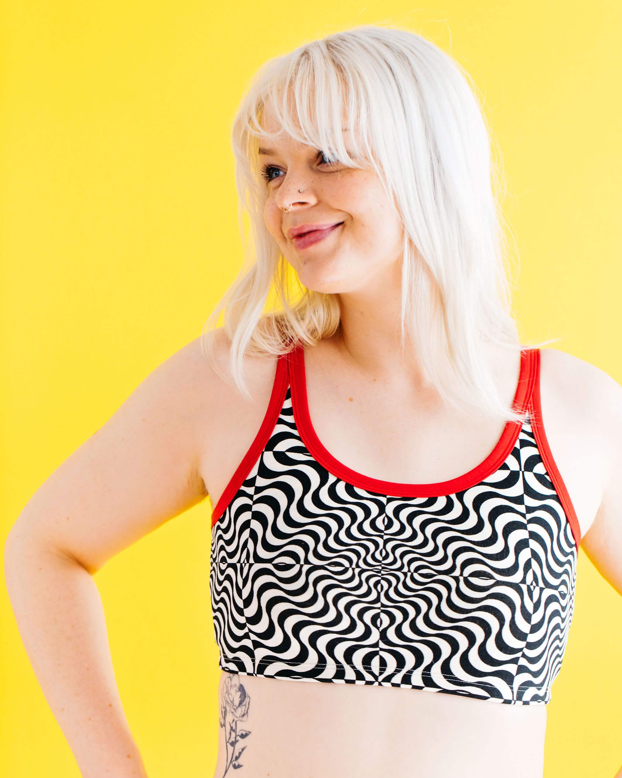 Close up of model wearing Thunderpants longline bra in Tropical Trippy - black and vanilla squiggles with red binding.