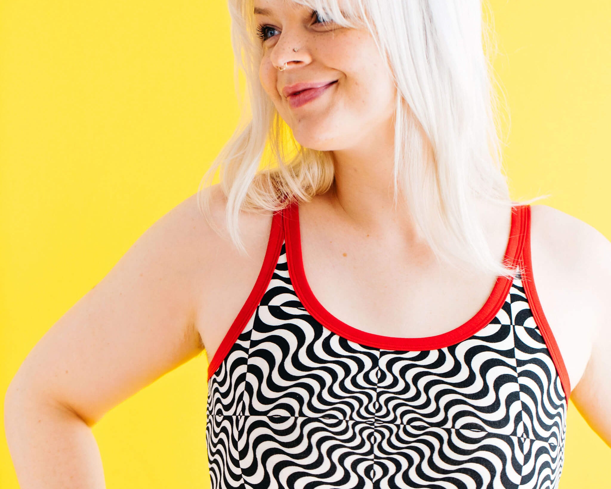 Close up of model wearing Thunderpants longline bra in Tropical Trippy - black and vanilla squiggles with red binding.