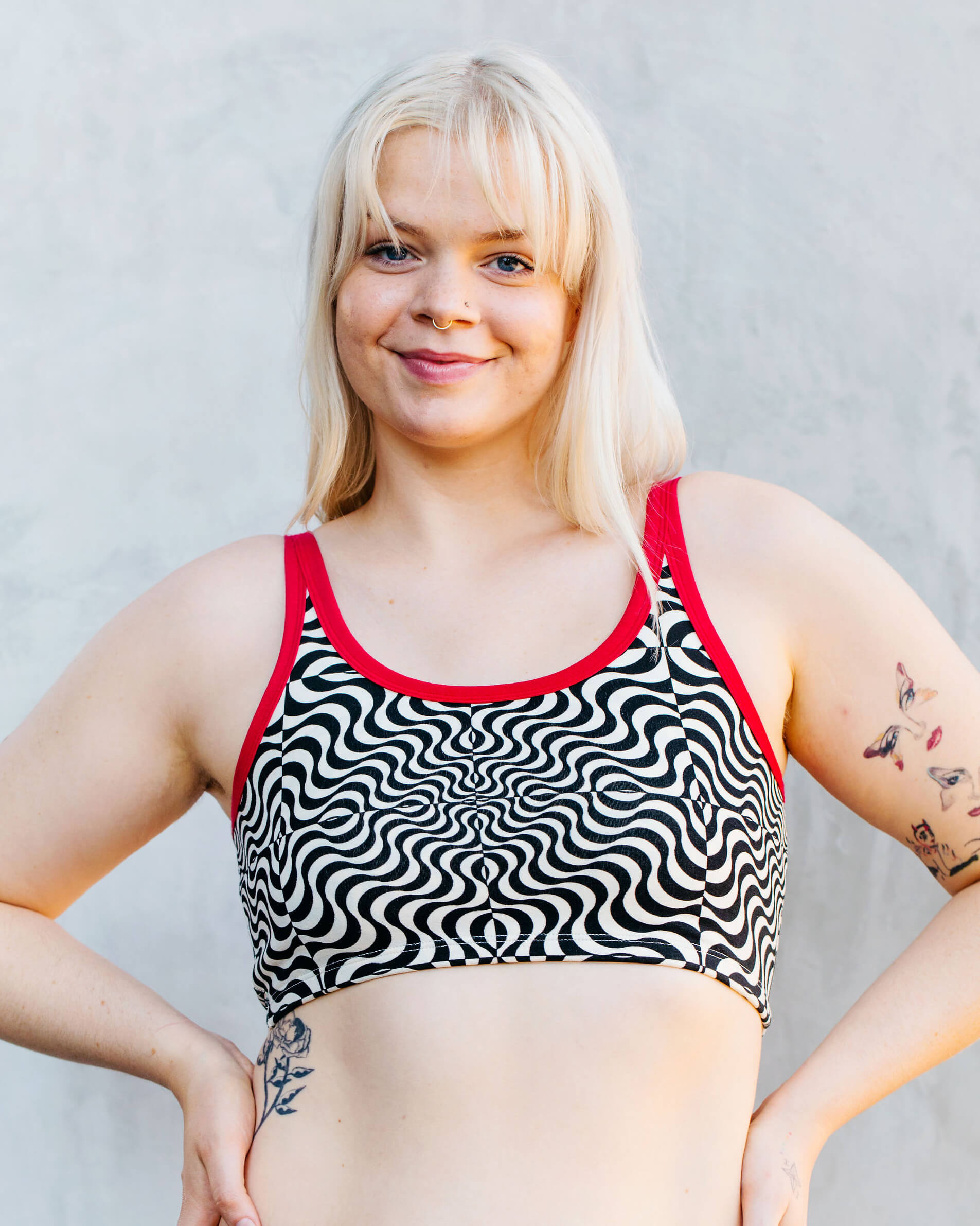 Close up of model wearing Thunderpants longline bra in Tropical Trippy - black and vanilla squiggles with red binding.