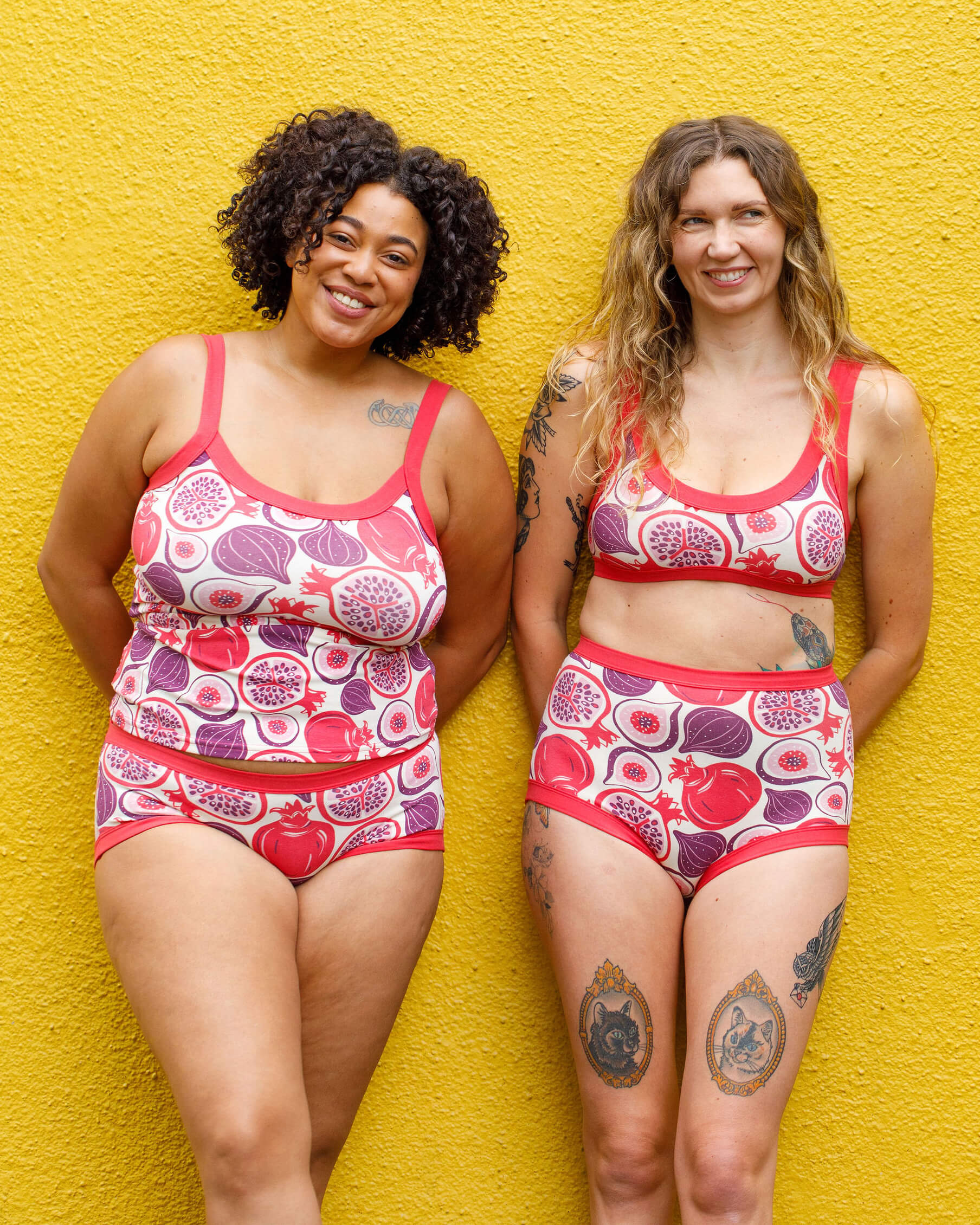 Two models wearing various Thunderpants items in Two Fruits - pomegranates and figs.