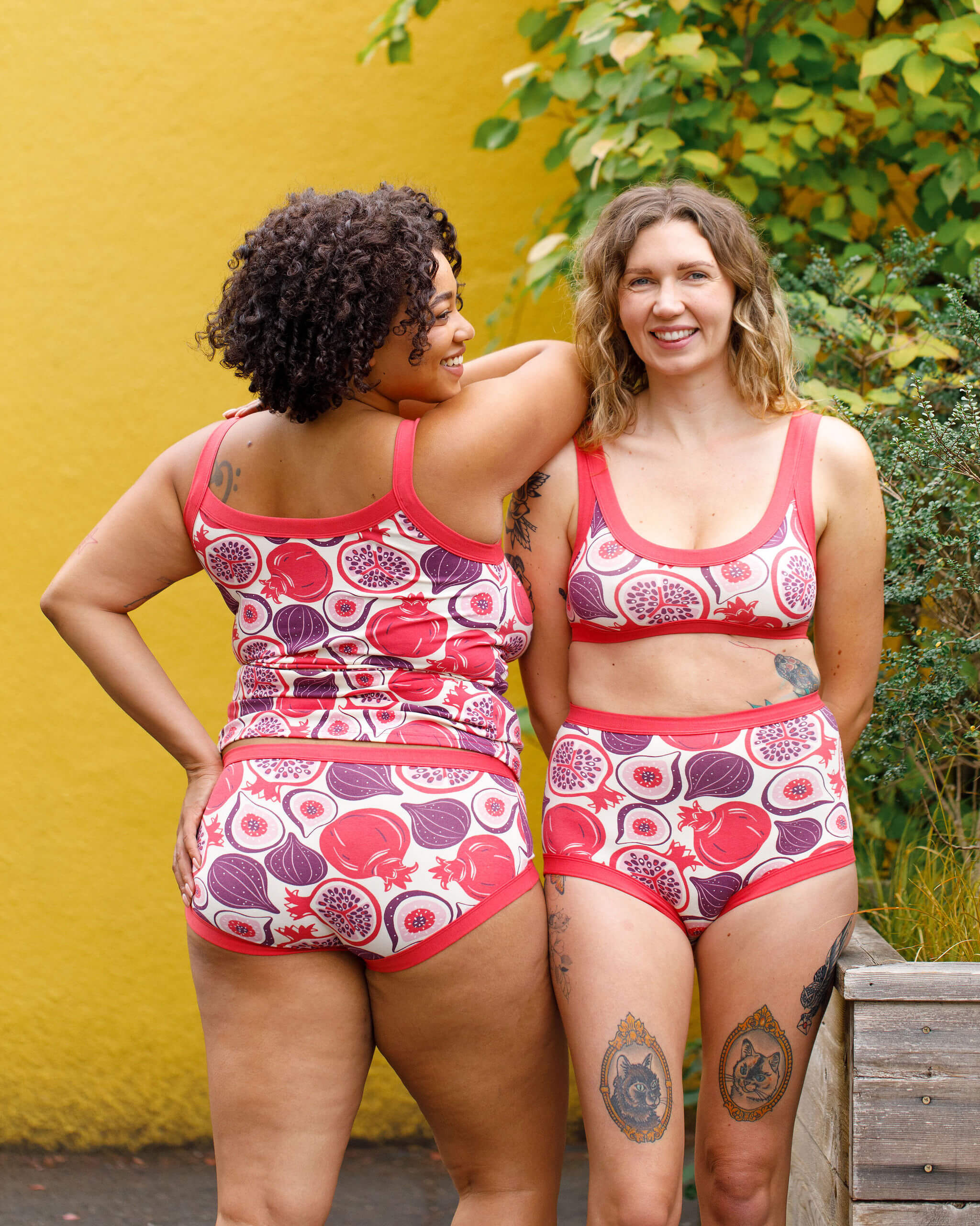 Two models wearing various Thunderpants items in Two Fruits - pomegranates and figs.