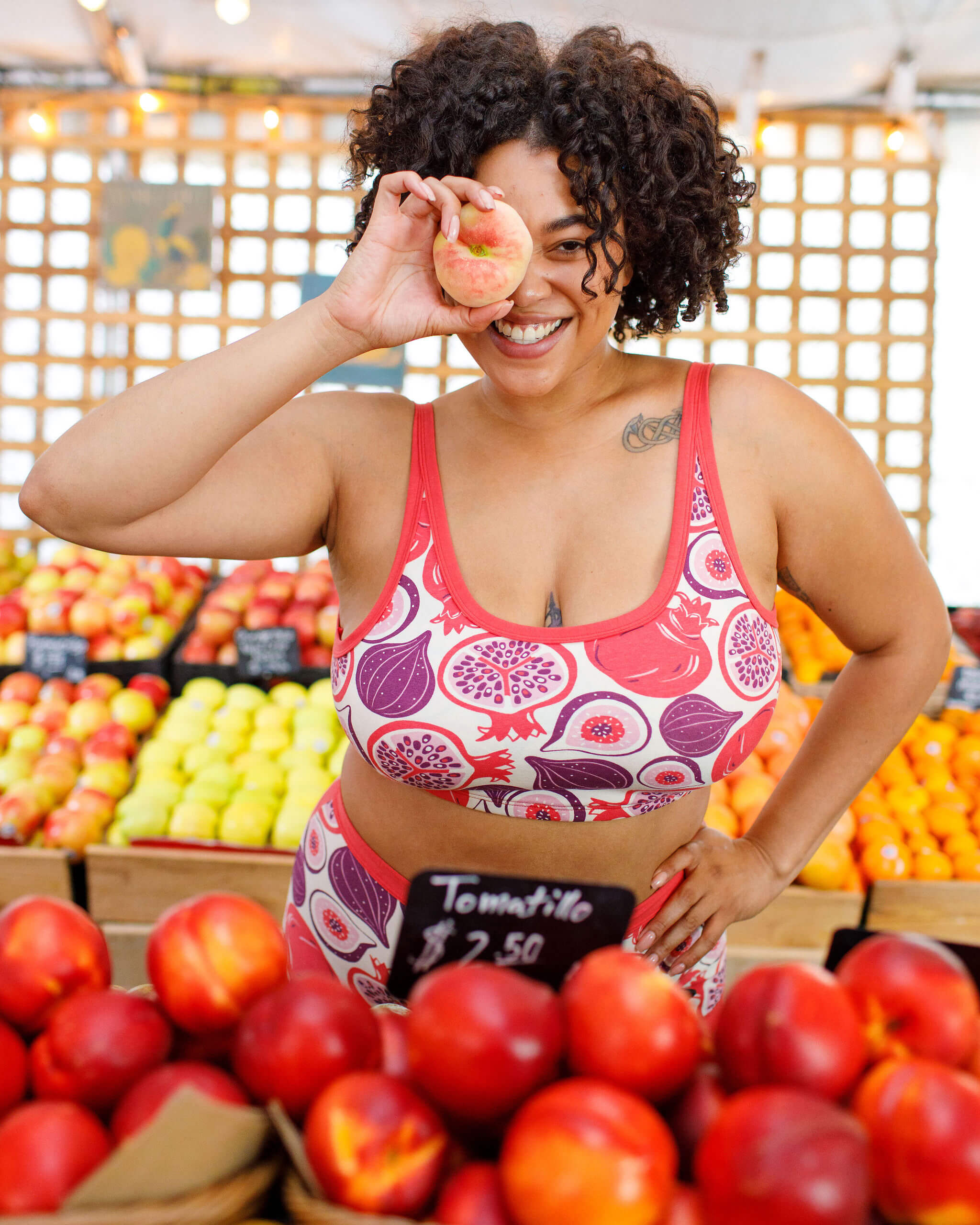 Close up of model wearing Thunderpants Longline Bra in Two Fruits - pomegranates and figs.