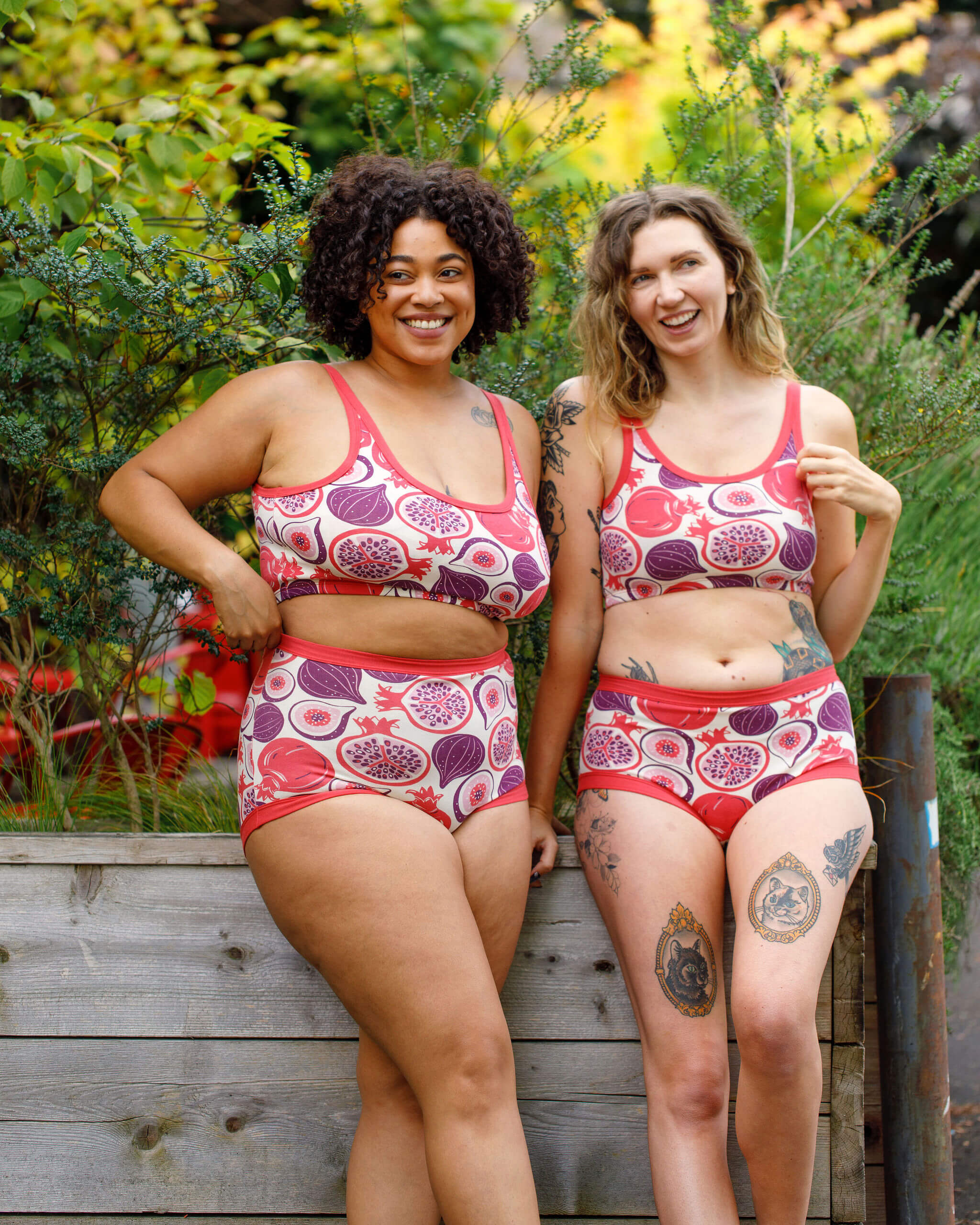 Two models wearing Thunderpants Longline Bras and underwear in Two Fruits - pomegranates and figs.