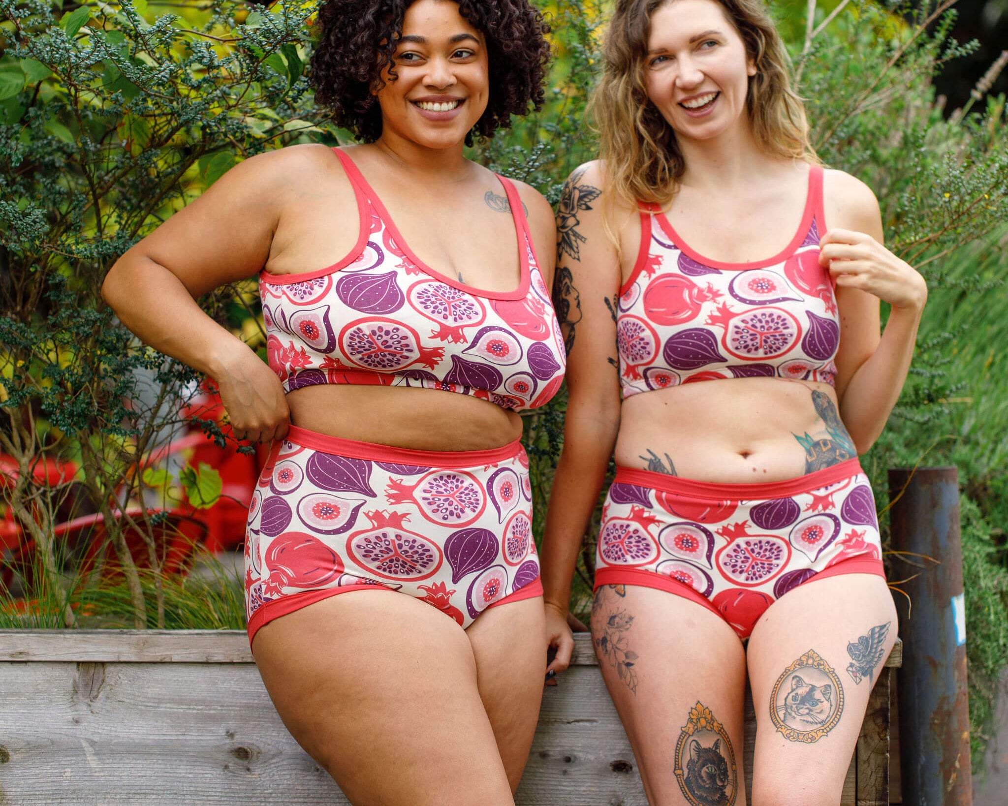 Two models wearing Thunderpants Longline Bras and underwear in Two Fruits - pomegranates and figs.