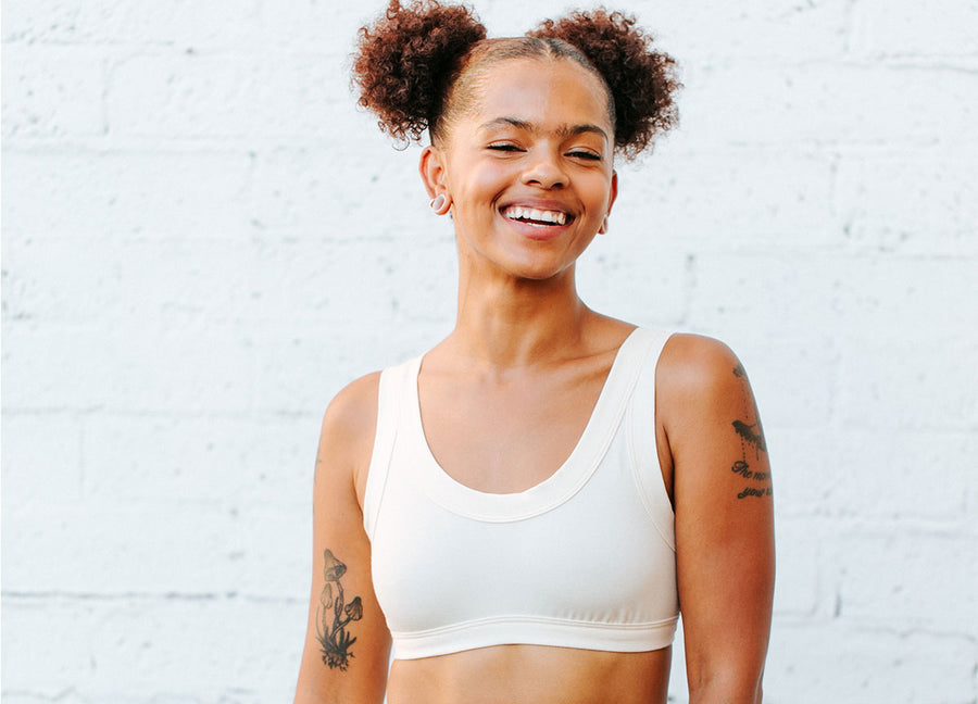 Model smiling while wearing Thunderpants Bralette in natural Plain Vanilla.
