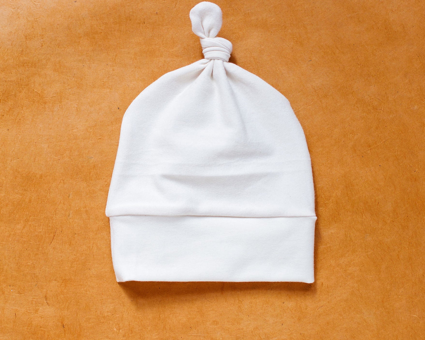 Flat lay of Thunderpants Scrap Baby Hat in Plain Vanilla.