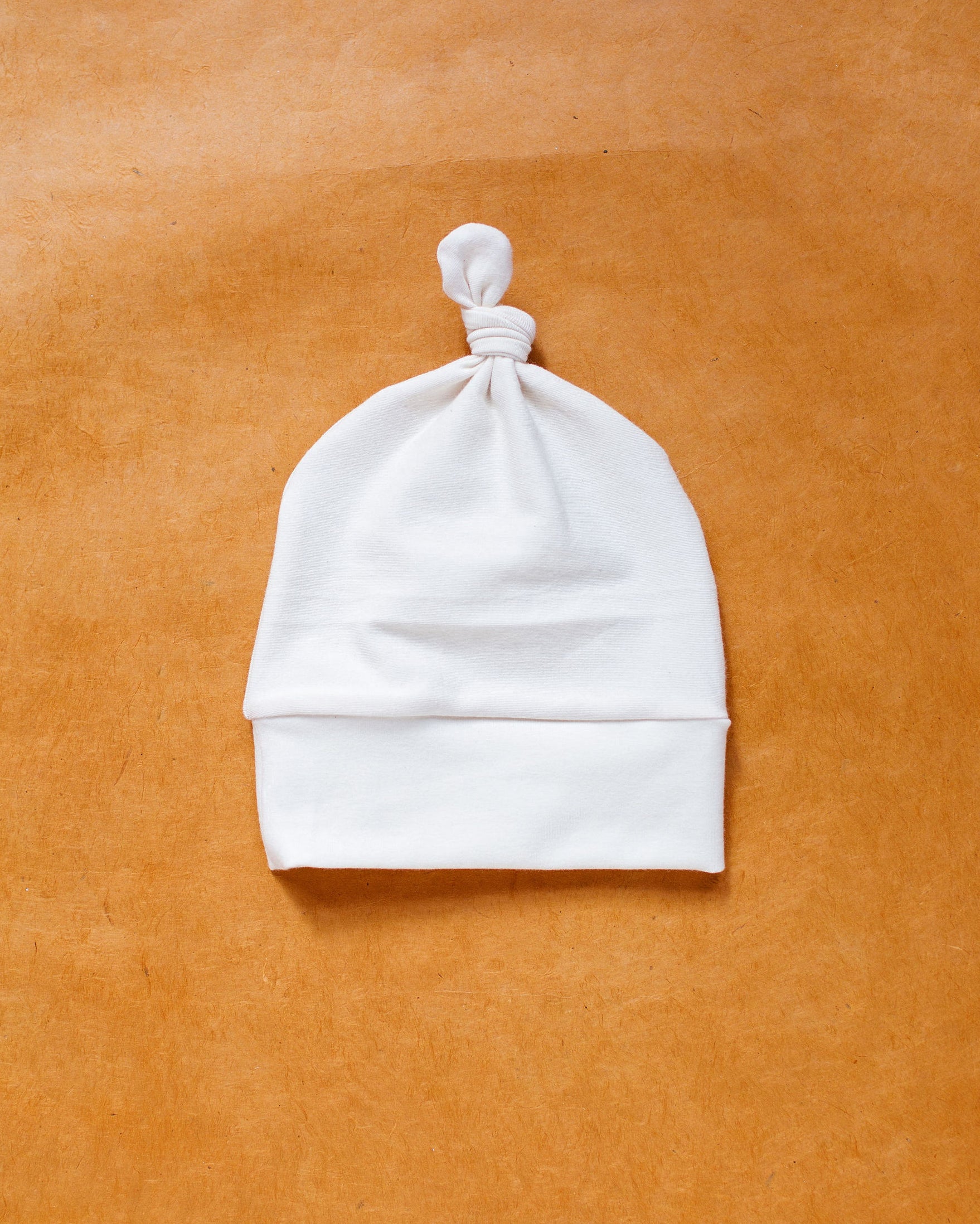 Flat lay of Thunderpants Scrap Baby Hat in Plain Vanilla.