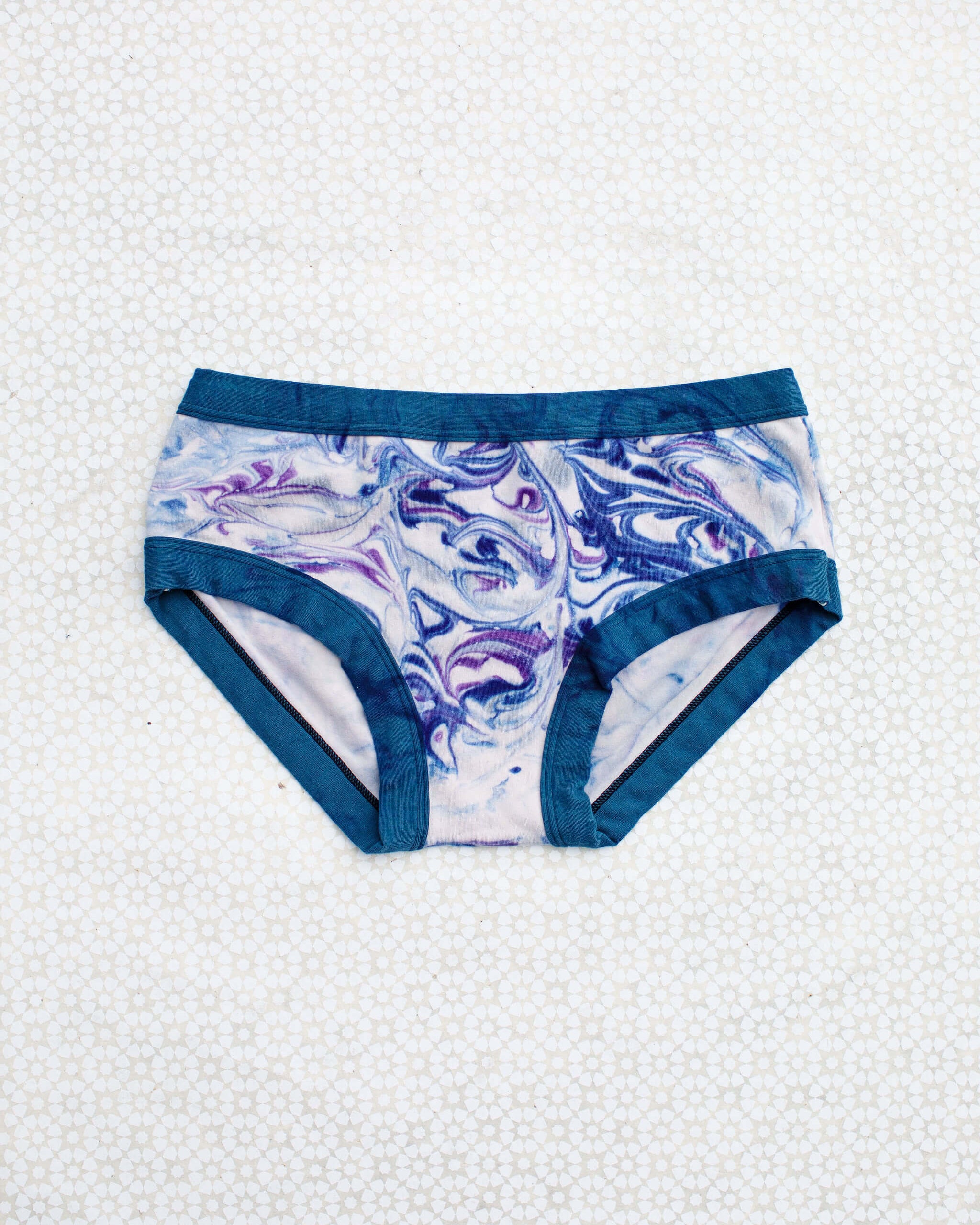 Flat lay of Thunderpants Hipster style underwear in Winter Blues Marble dye - different blues and purples swirled to look like marble. 