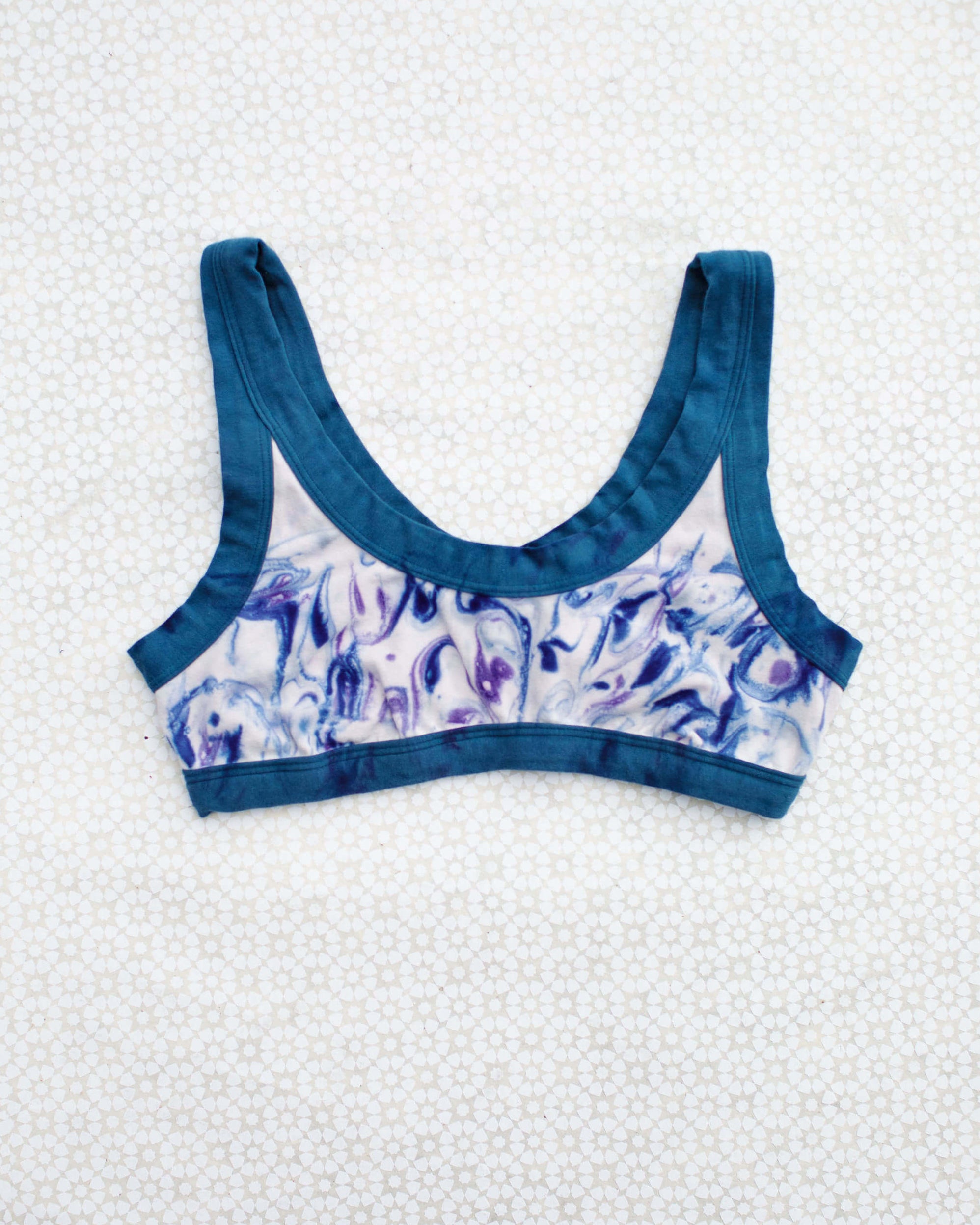 Flat lay of Thunderpants Bralette in Winter Blues Marble dye - different blues and purples swirled to look like marble. 