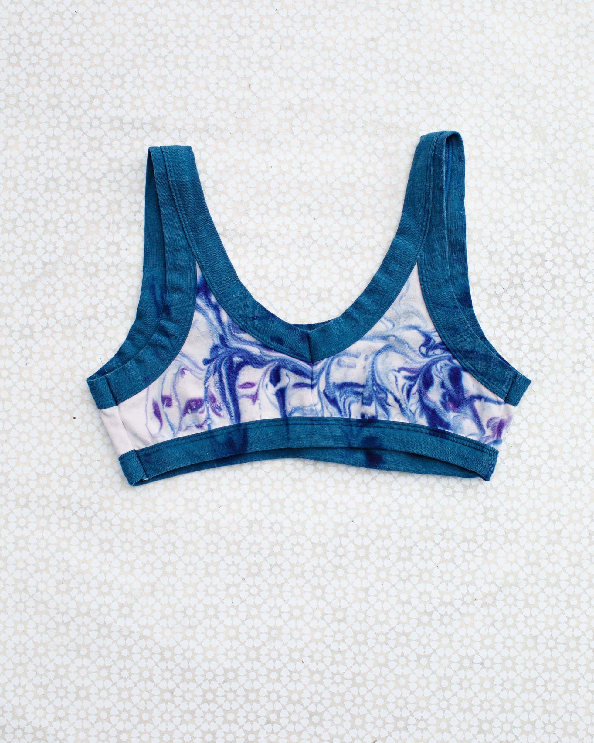 Flat lay of Thunderpants Bralette in Winter Blues Marble dye - different blues and purples swirled to look like marble. 