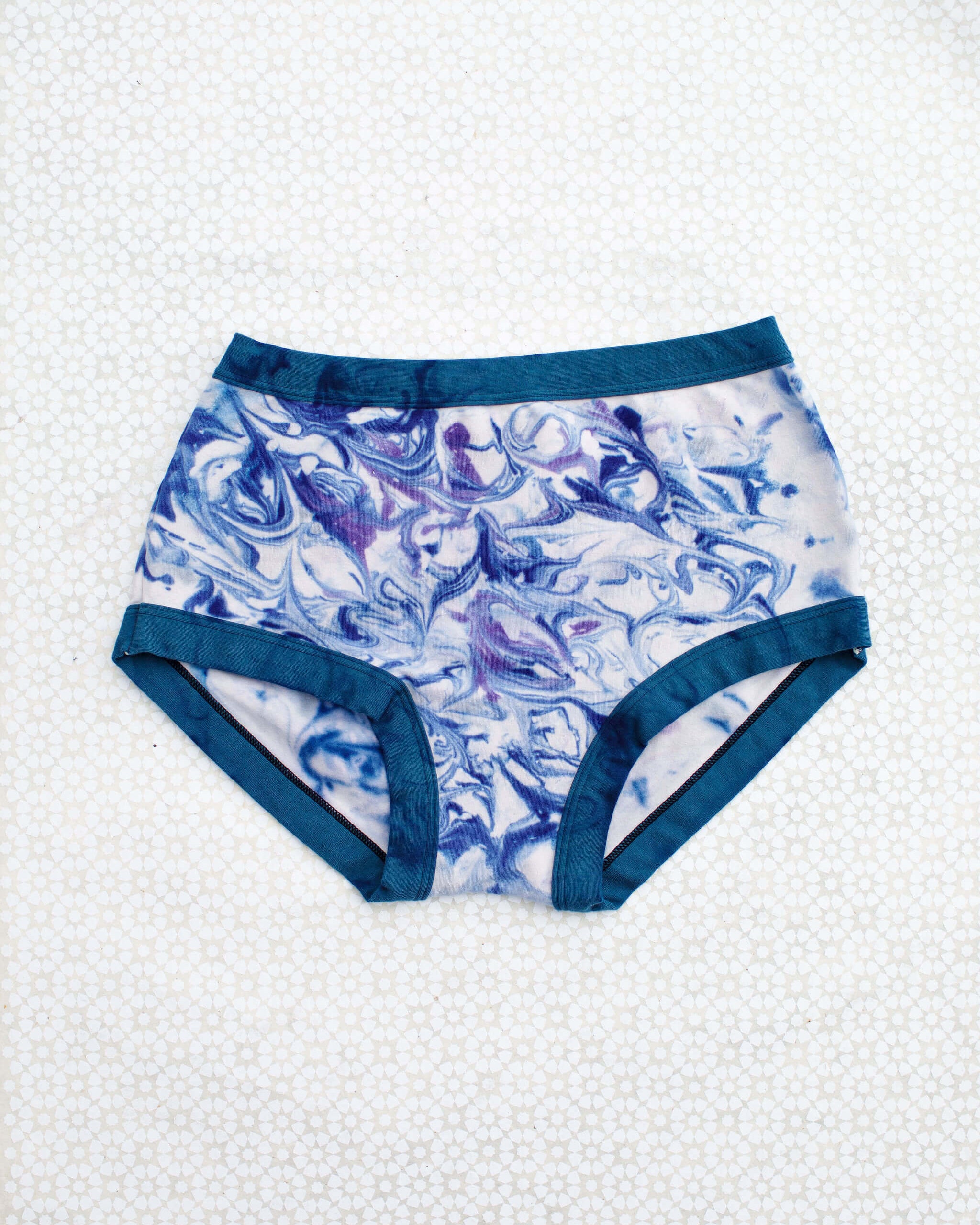 Flat lay of Thunderpants Original style underwear in Winter Blues Marble dye - different blues and purples swirled to look like marble. 